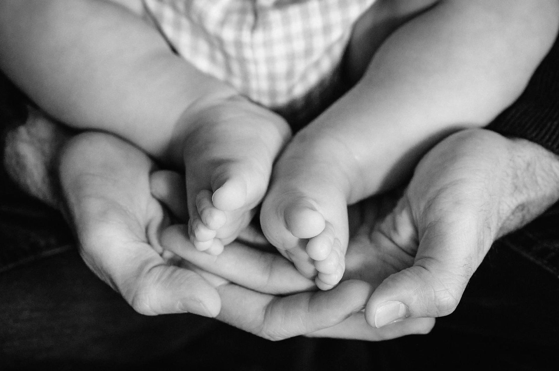 a close up of a person holding a baby's foot