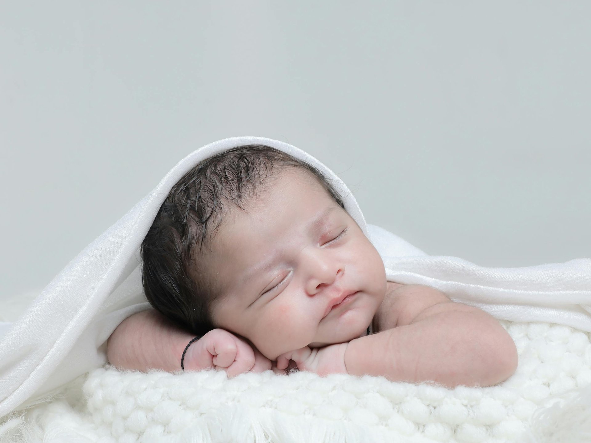 sleeping baby on white textile