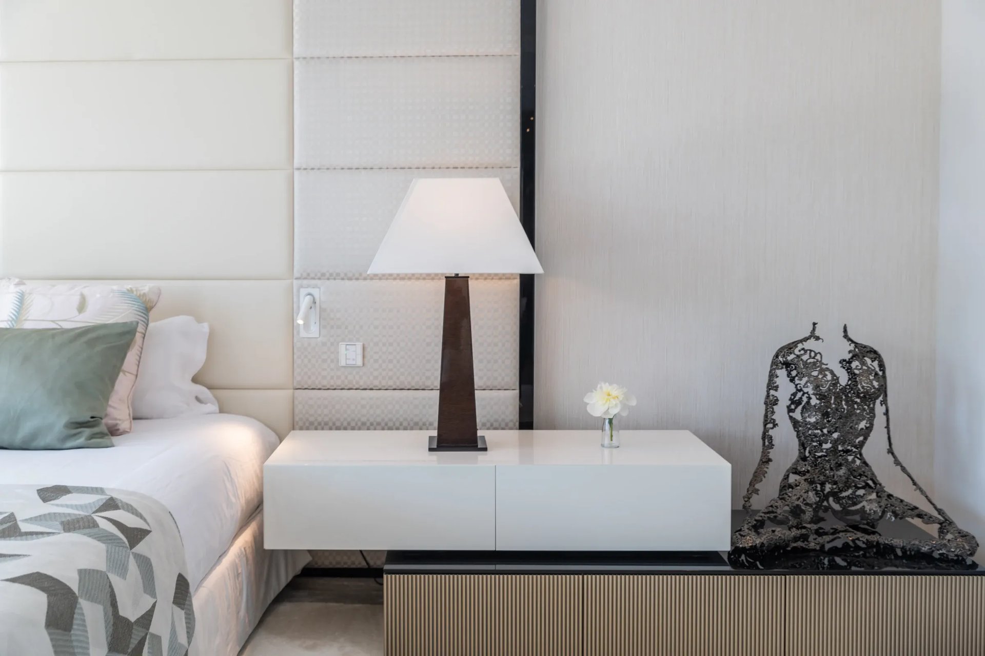 Modern bedside table with lamp and sculpture at Villa Serenity