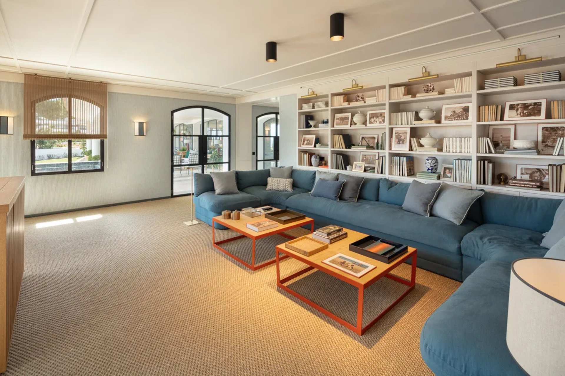 Library at Villa La Gratitud with custom bookshelves and deep blue sofa