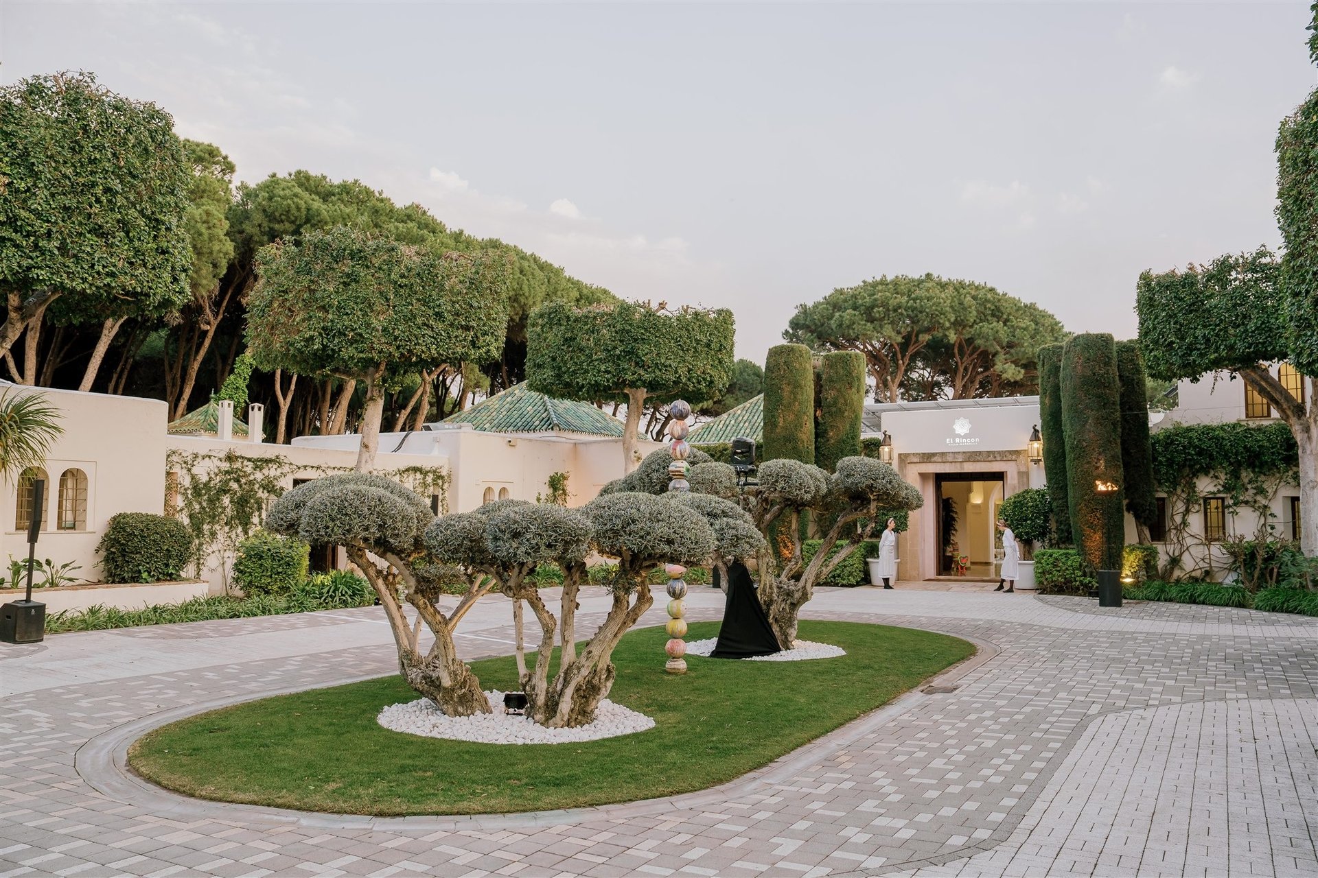 Elegant entrance of Villa El Rincon set up for a corporate event, with manicured trees and evening ambiance