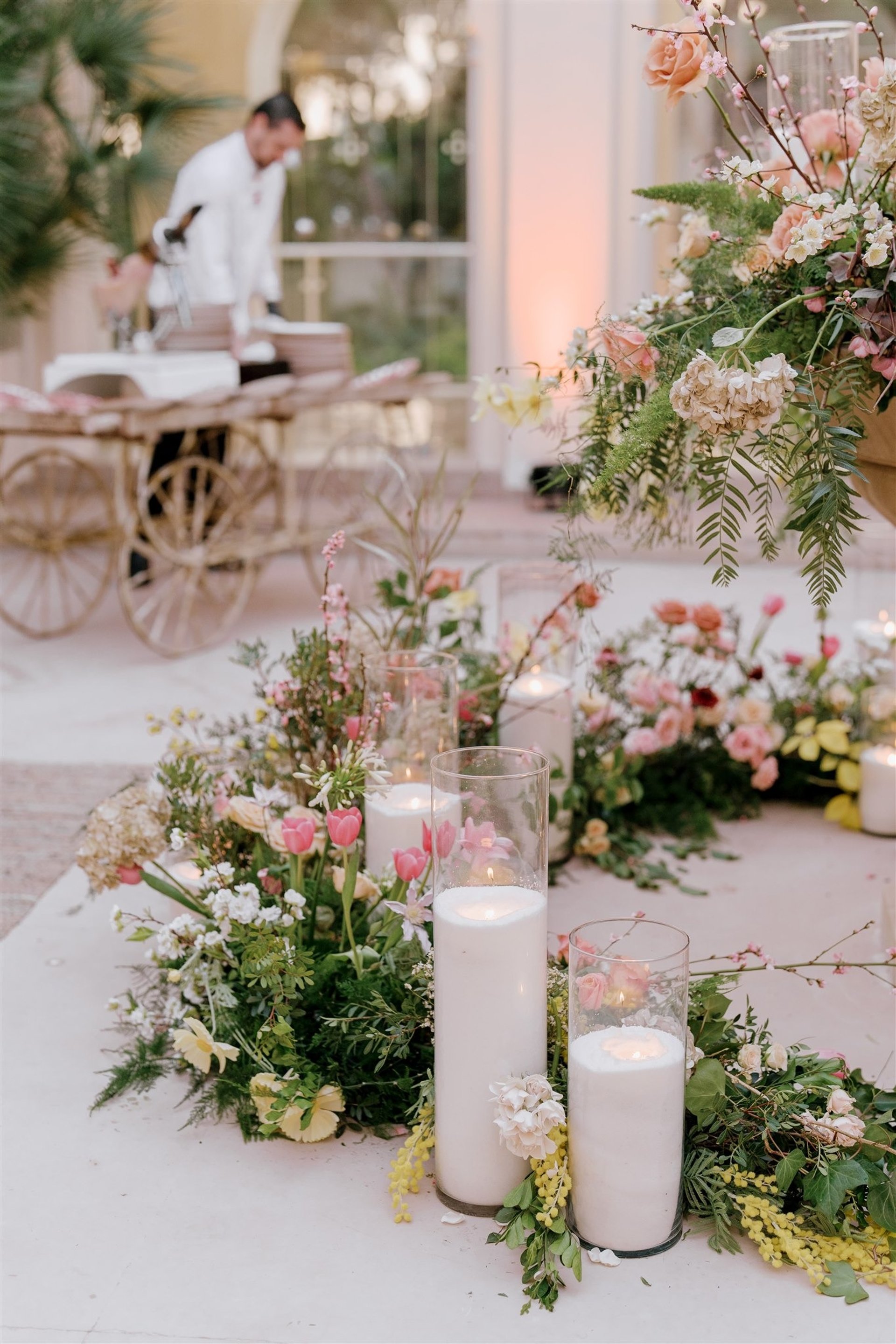 Elegant floral and candle arrangement at Villa El Rincon event setup, with catering service in the background