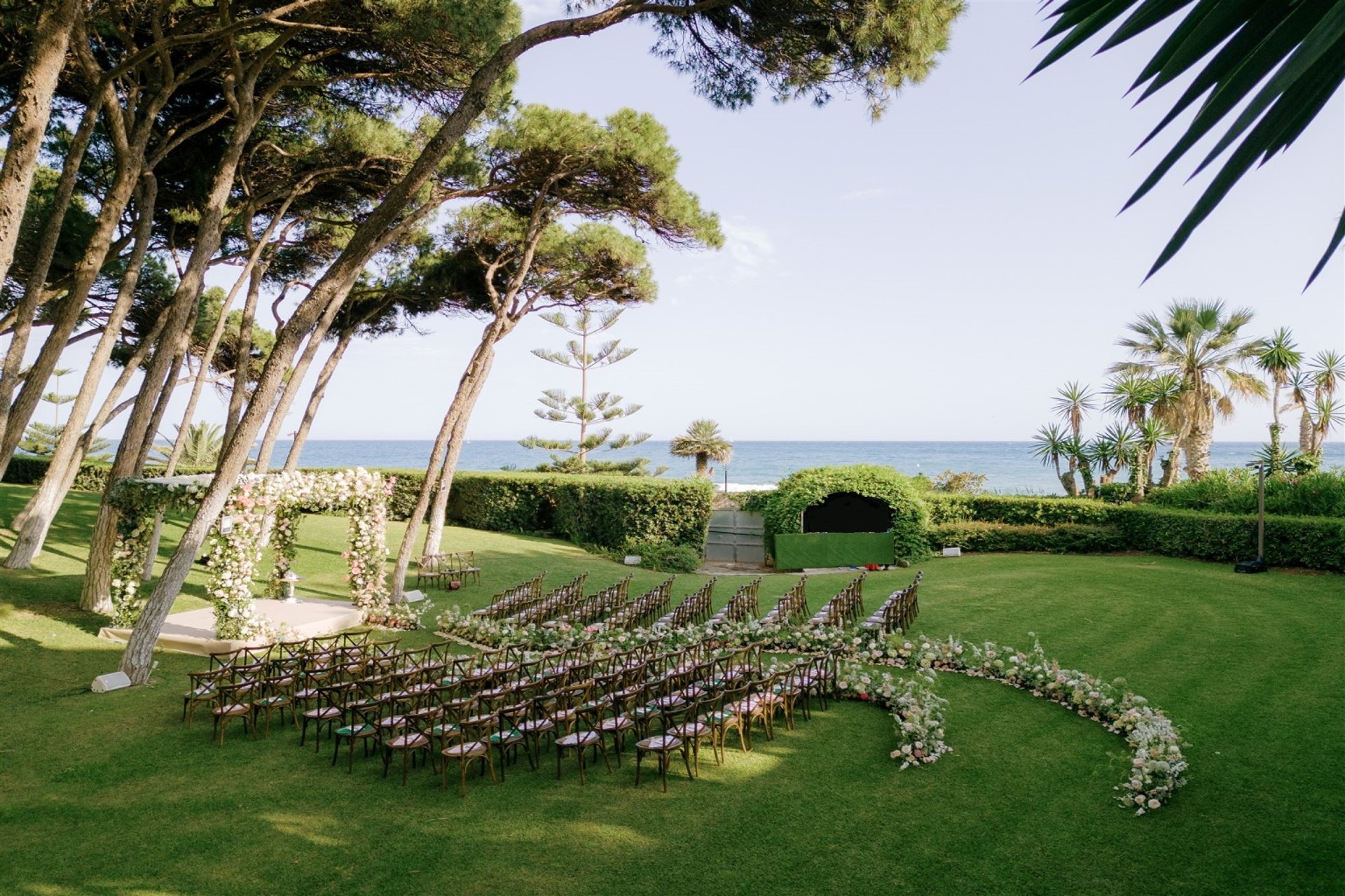 Seaside wedding ceremony setup at Villa El Rincon with floral arch and elegant seating