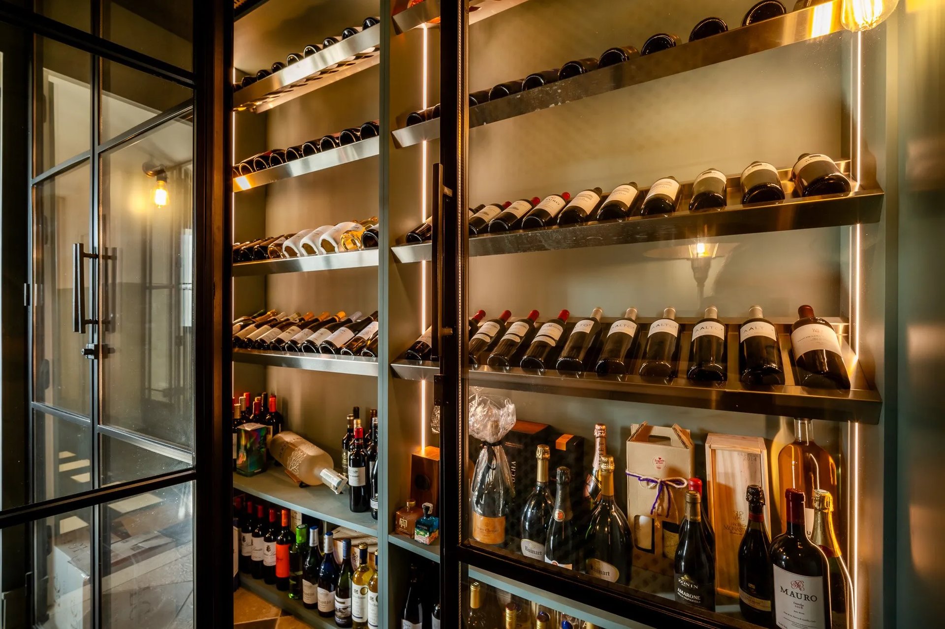 Wine cellar at Villa La Gratitud with backlit shelving and curated bottles
