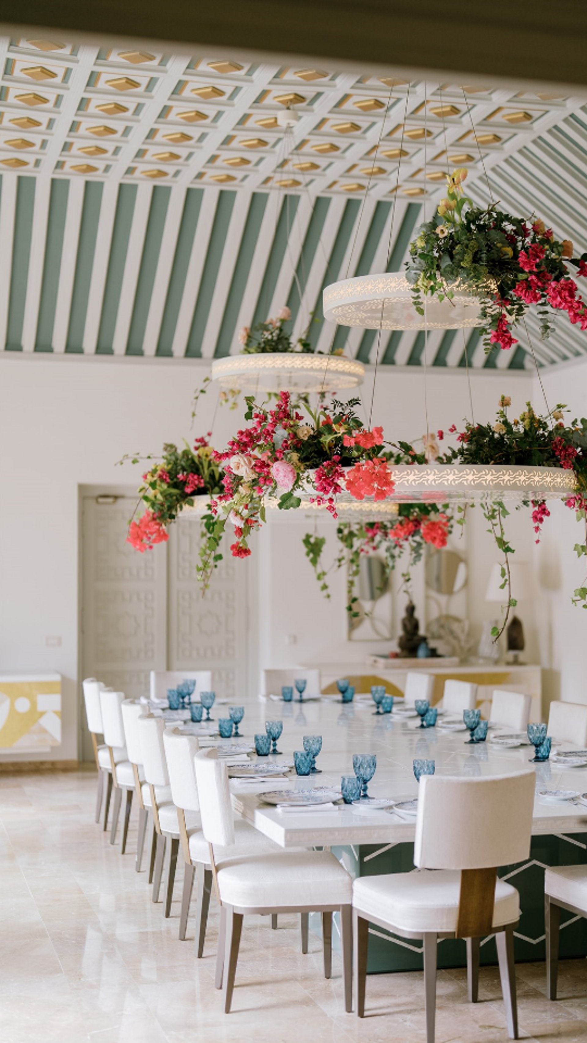 Dining room at Villa El Rincon featuring ornate ceilings with hanging lights and floral decorations for a destination wedding