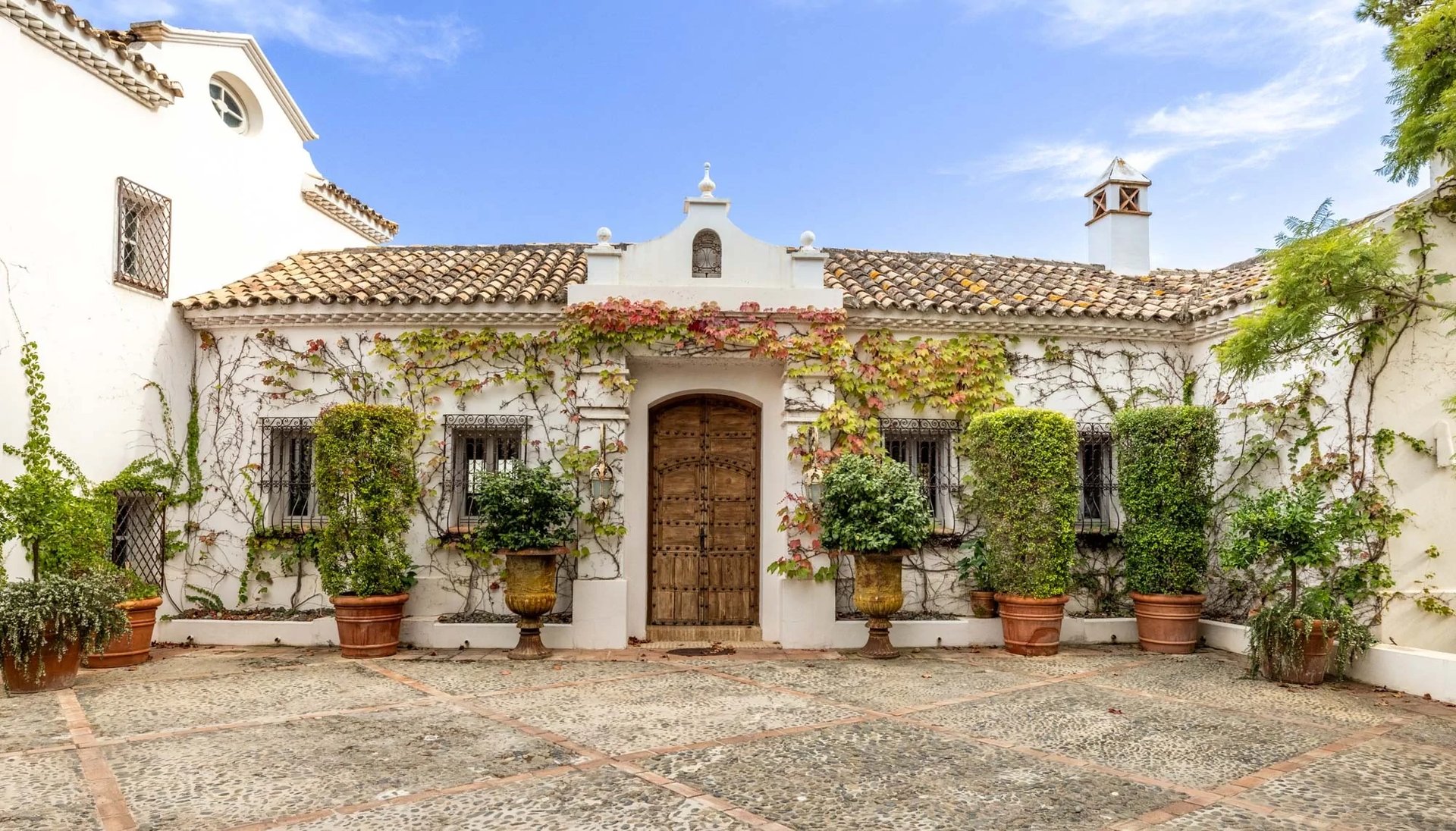 Historic Andalusian courtyard with tiled fountain and potted plants