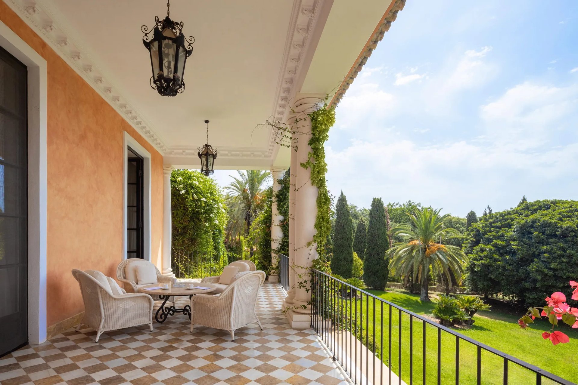 Shaded balcony terrace overlooking manicured palm gardens