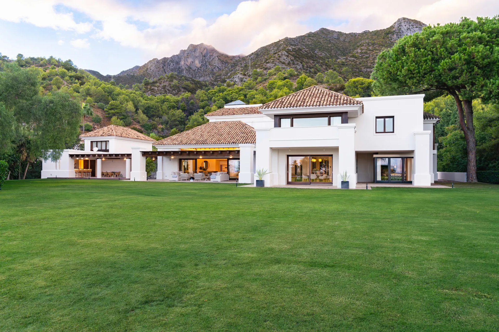 Rear façade with expansive lawn and mountain backdrop