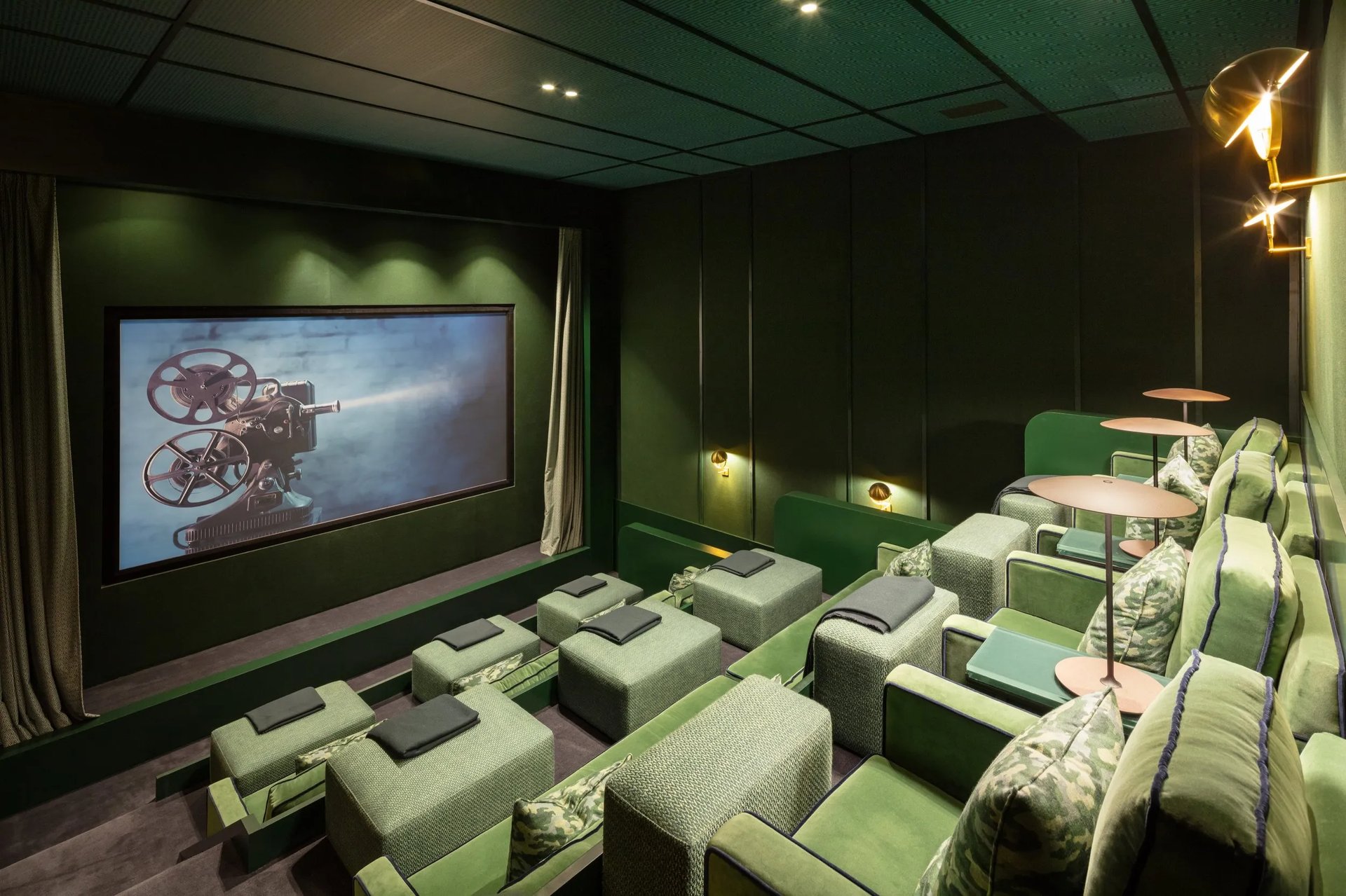Cinema room at Villa La Gratitud with plush green armchairs