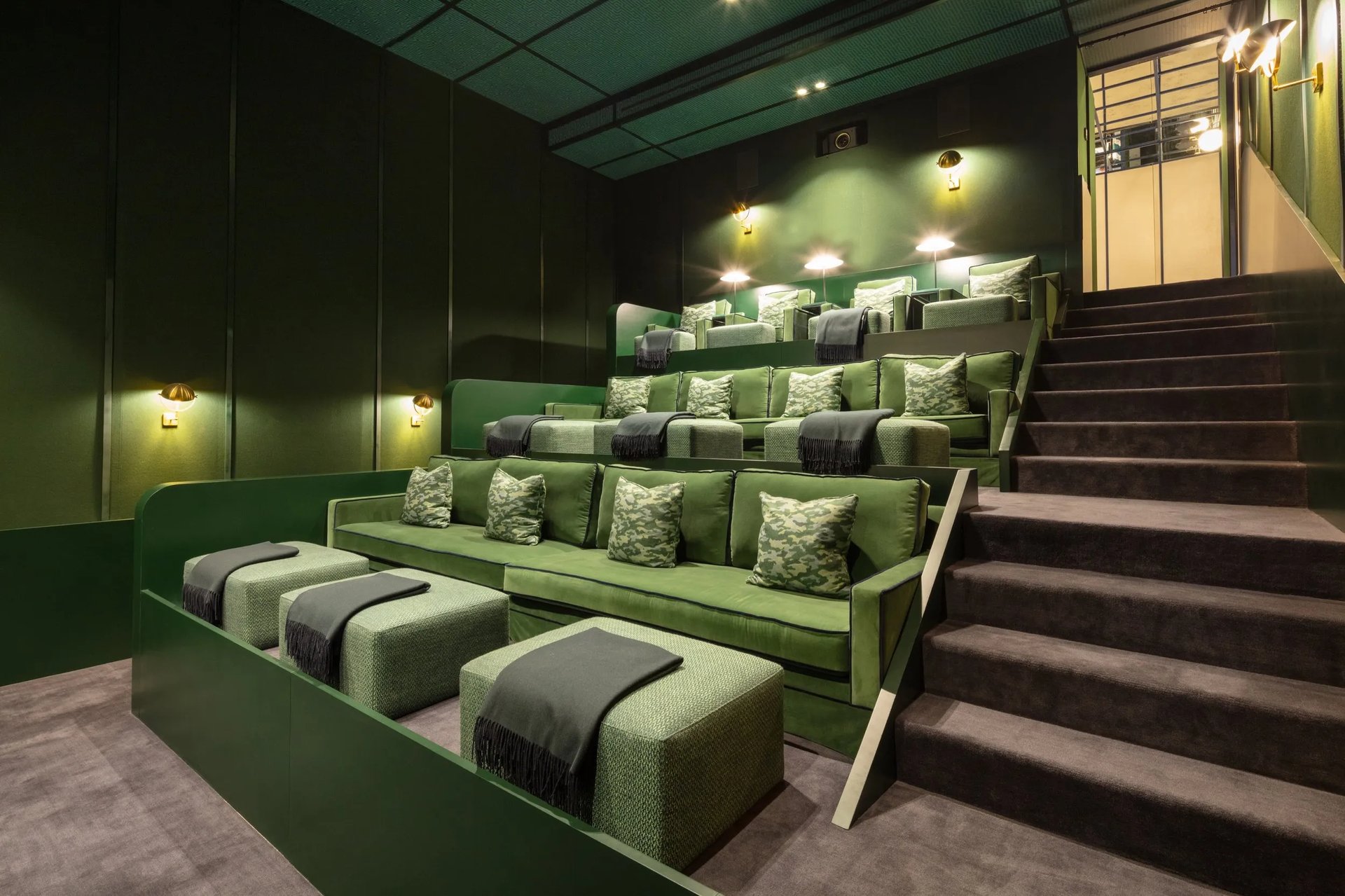 Cinema room at Villa La Gratitud with plush green armchairs