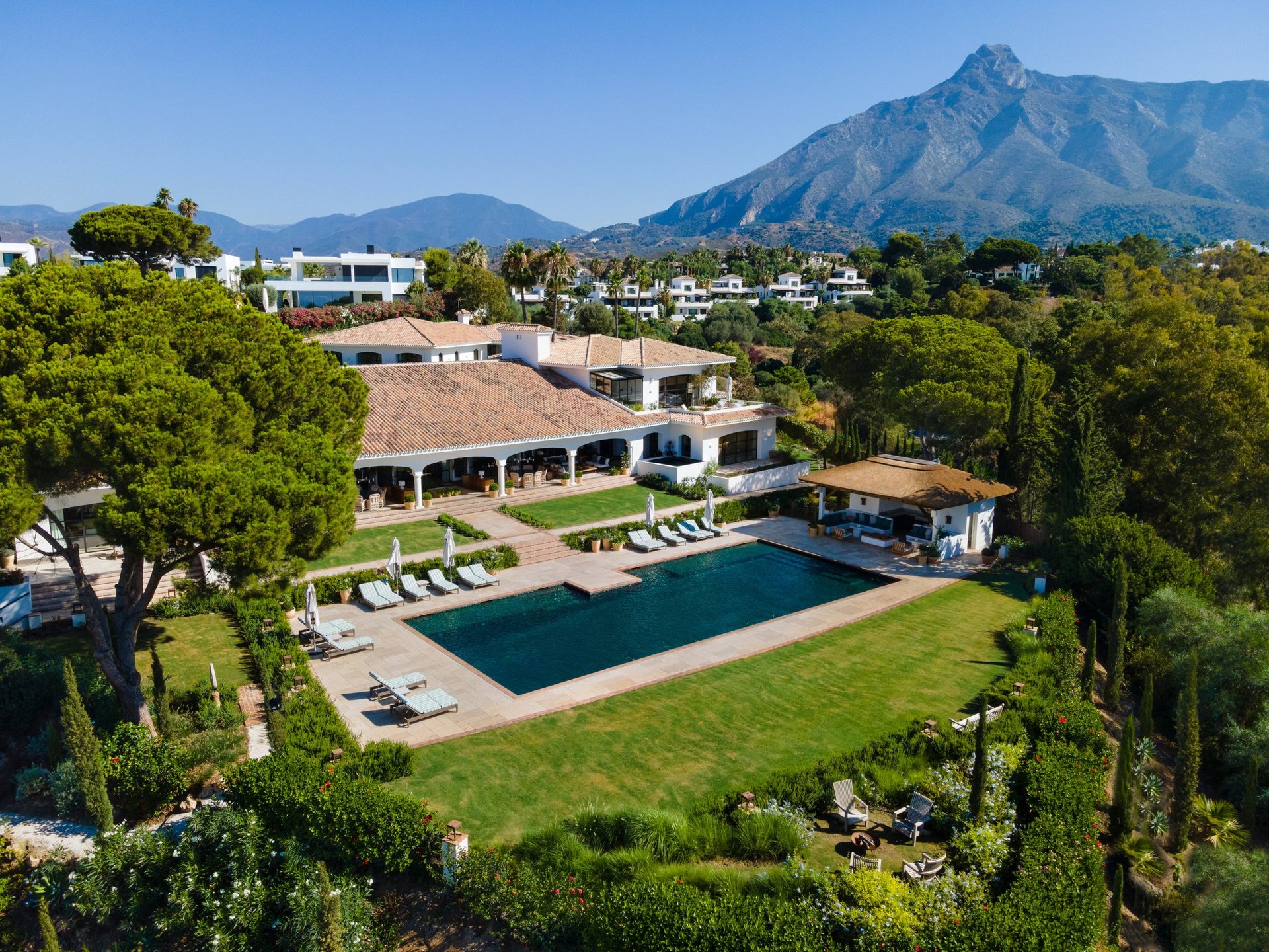 View from the shaded porch across the pool, with the Mediterranean Sea visible in the background.
