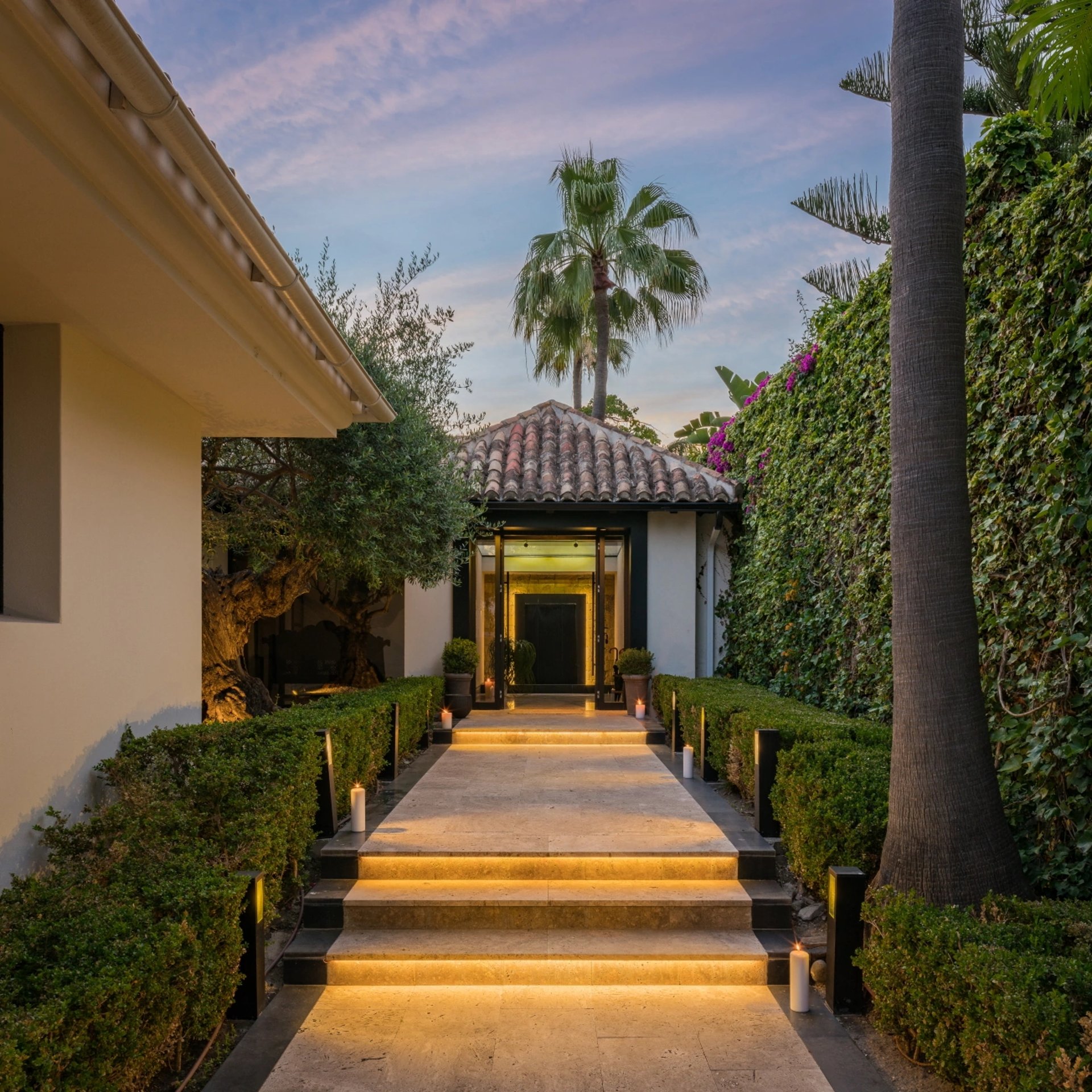 Villa El Olivo entrance pathway illuminated with warm evening lights