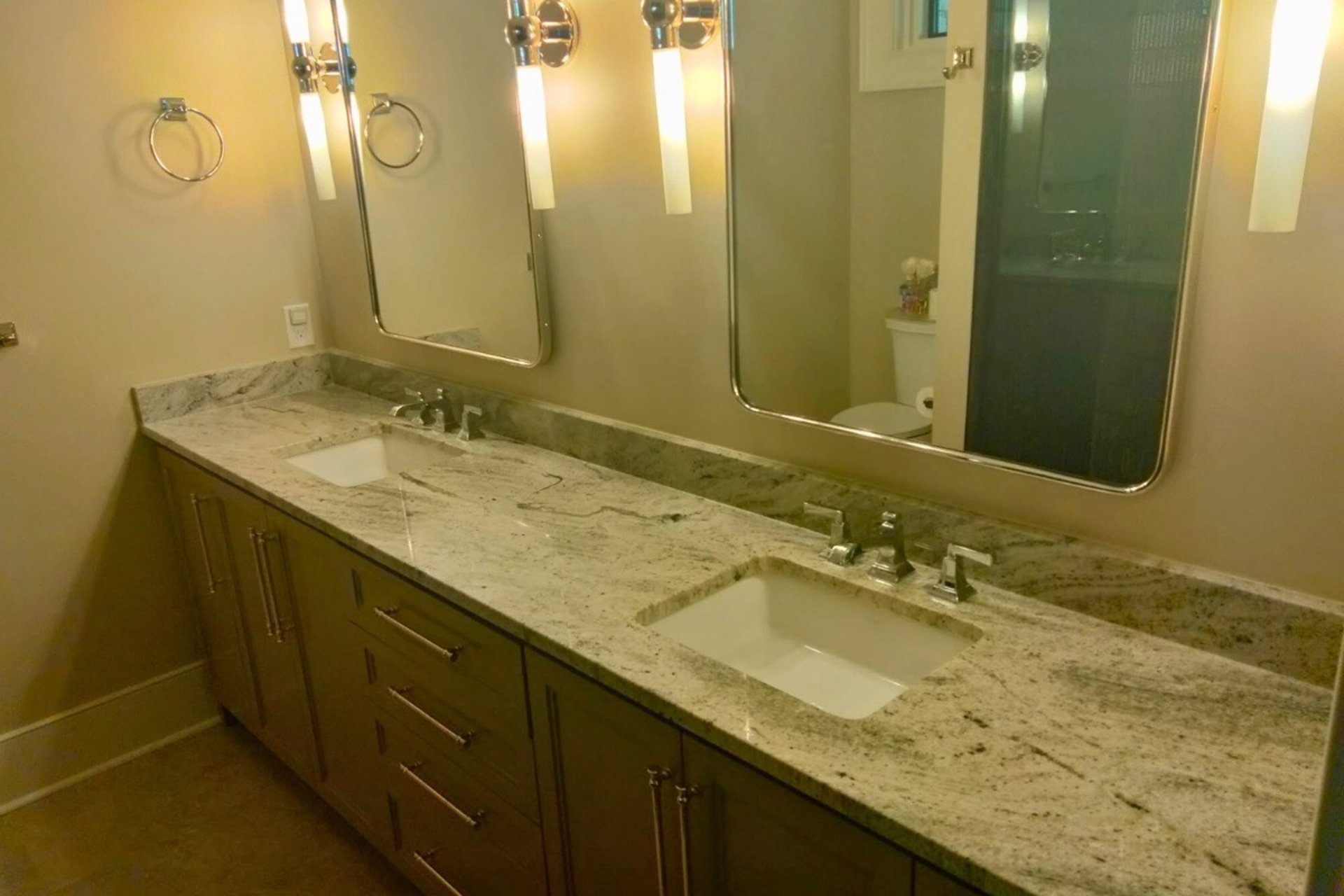 Bathroom vanity with white granite countertop, double sinks and mirror