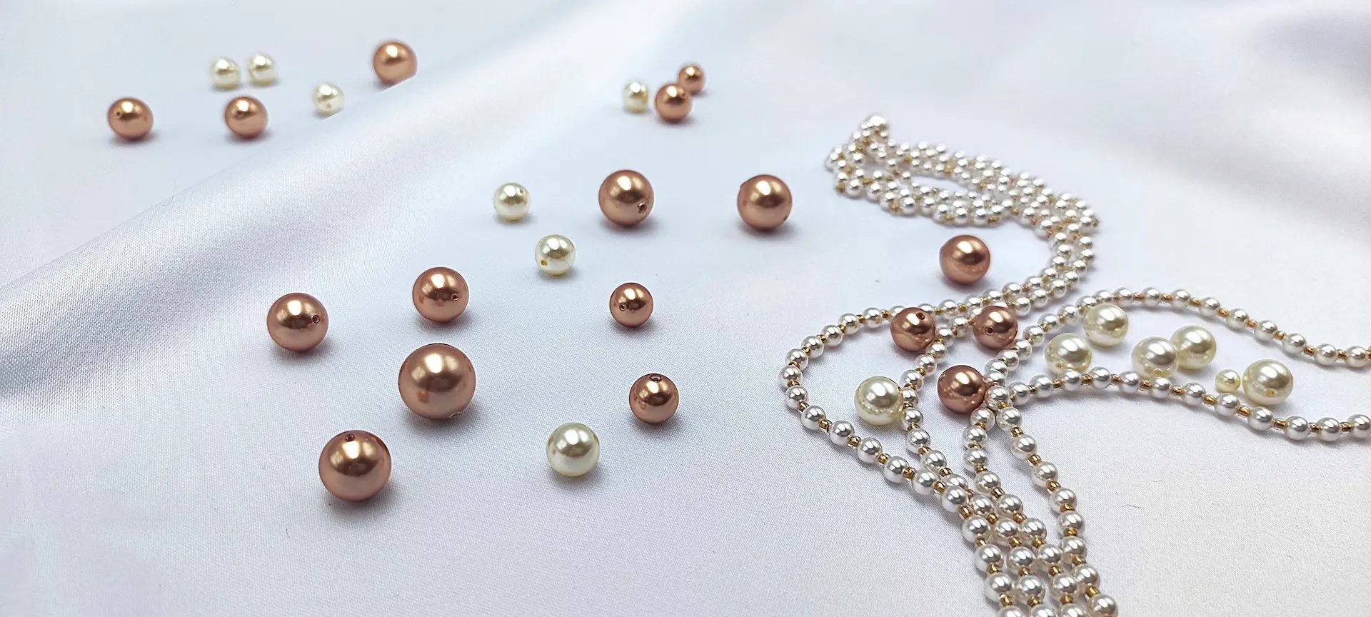 a pink pearl necklace and matching earrings on a marble surface