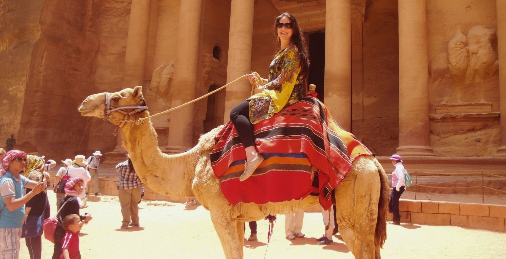 Foto da autora no camelo em frente ao tesouro de Petra.