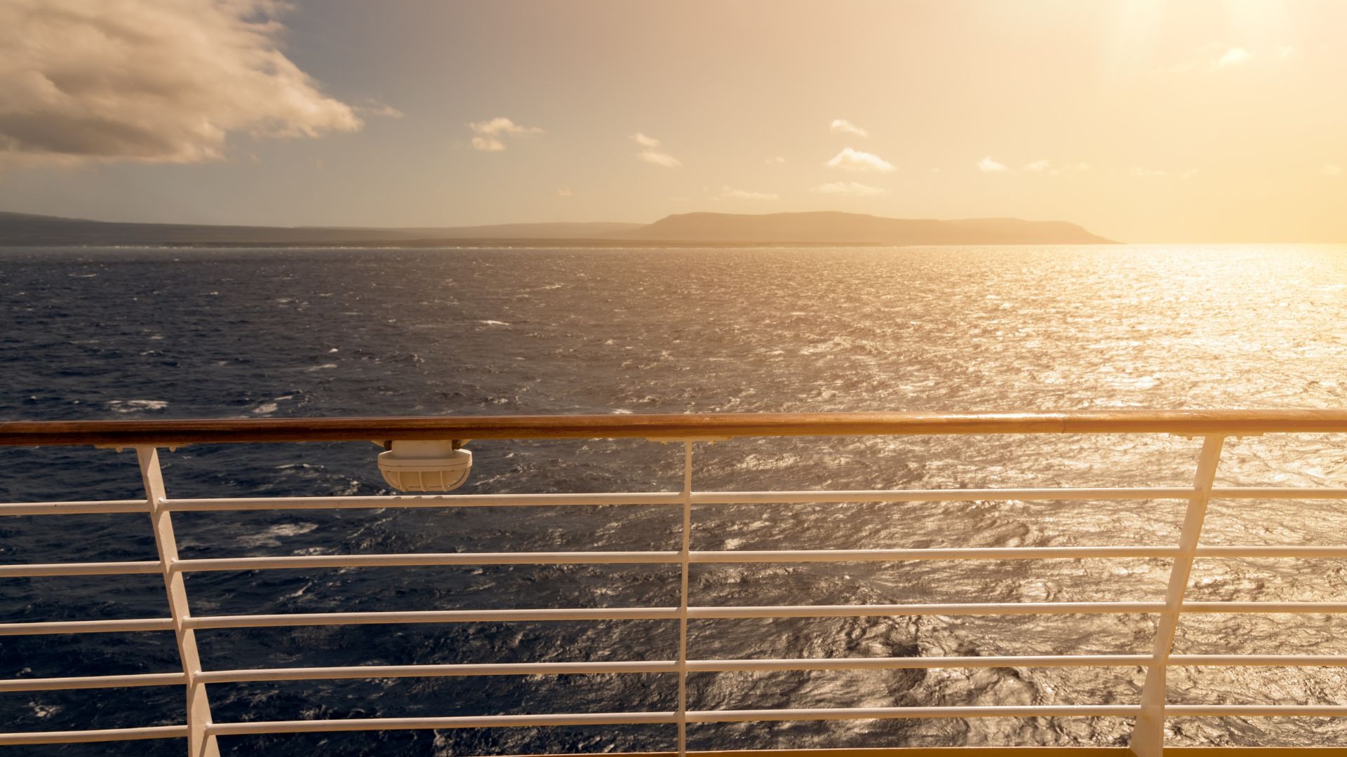 Deck do navio vista mar em navegação ao por do sol.