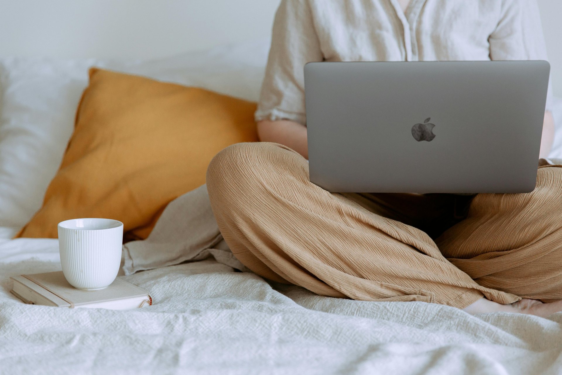 MacBook beside teacup with latte