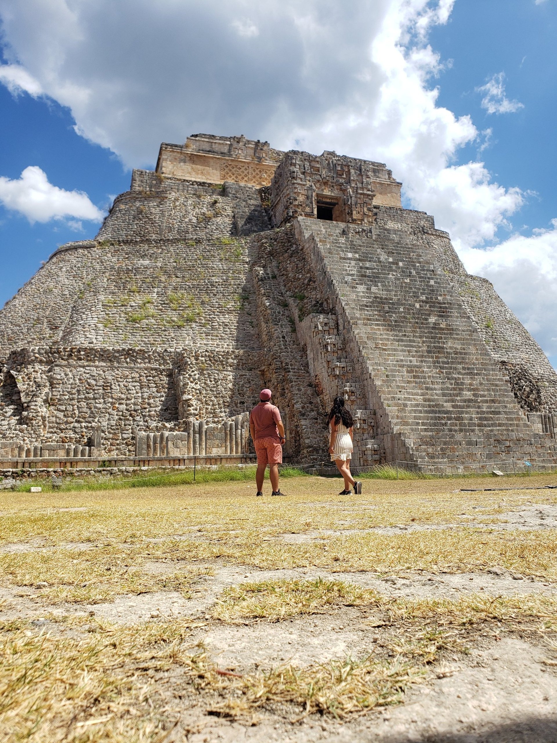 woman wearing yellow long-sleeved dress under white clouds and blue sky during daytime