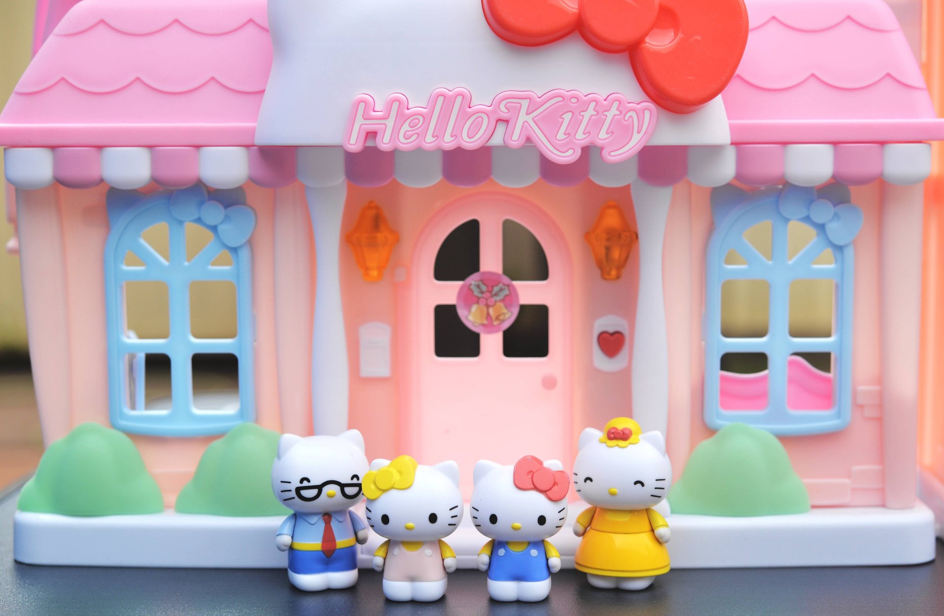 a neon hello kitty sign on a brick wall