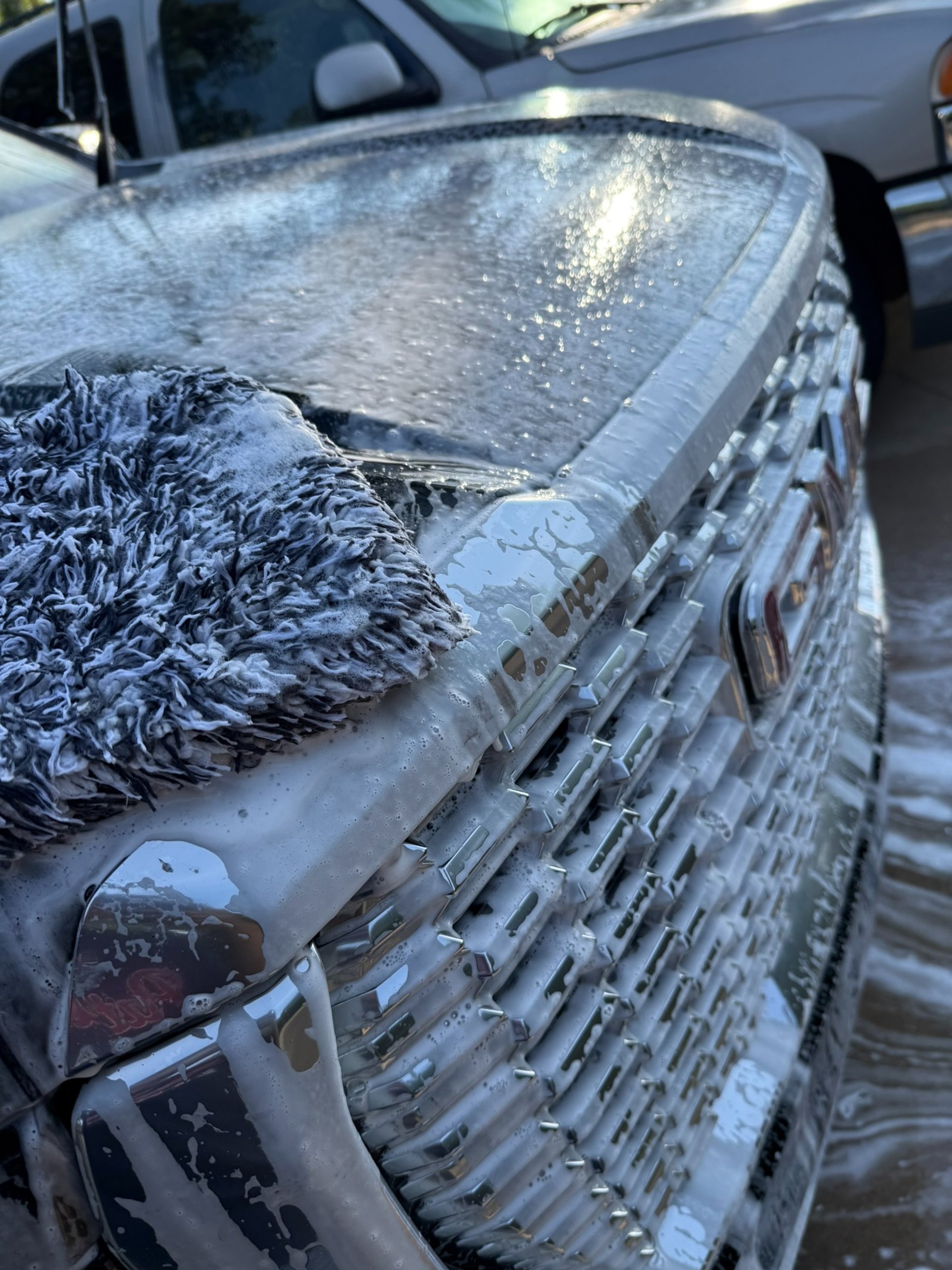 a person washing a car with a sponge