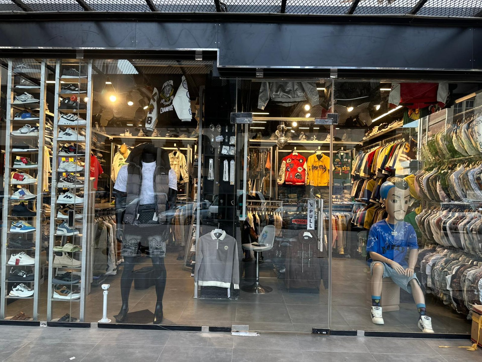 folded black Play shirt beside iPhone X, digital watch, and sneakers