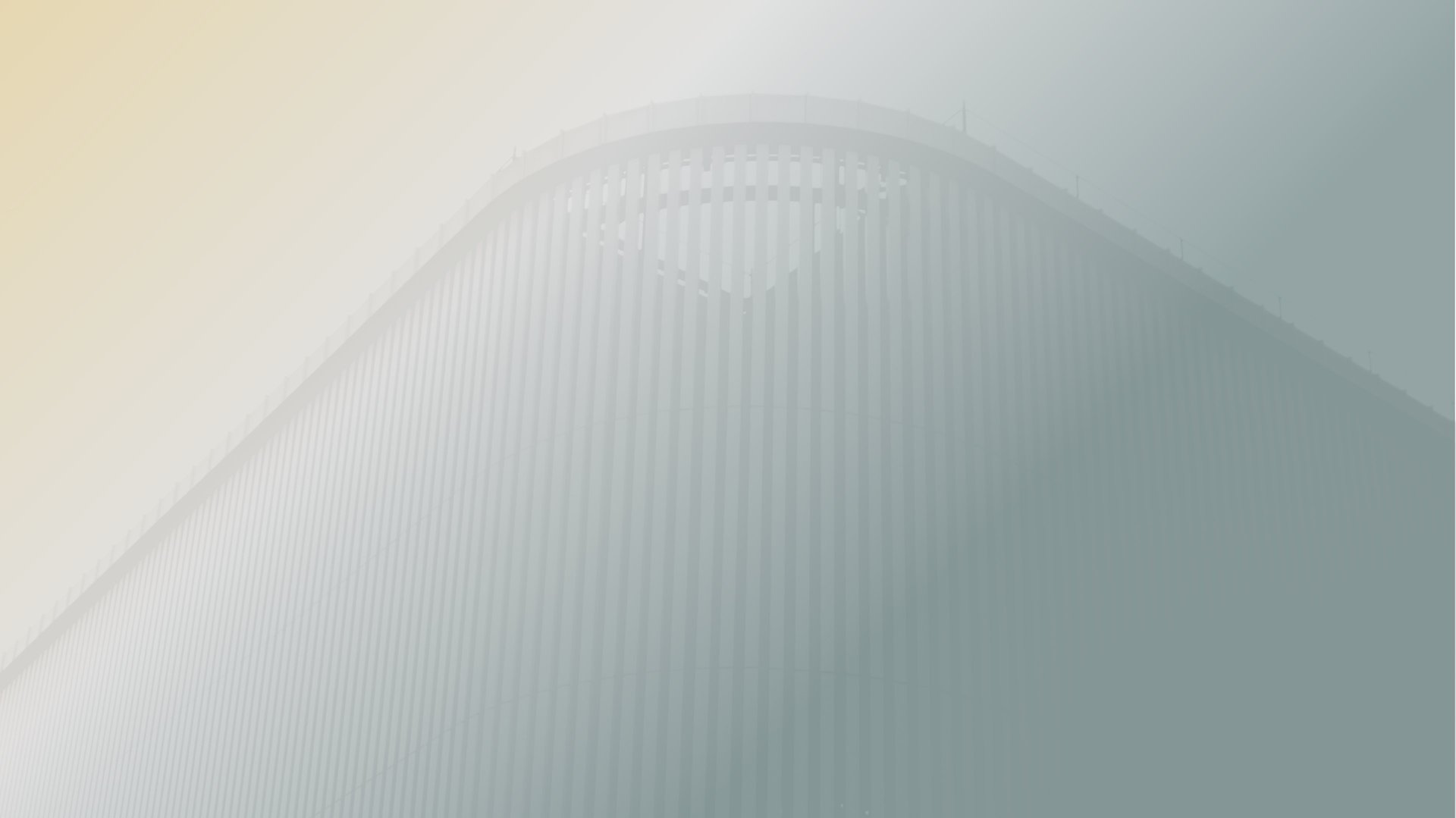 an abstract photo of a curved building with a blue sky in the background