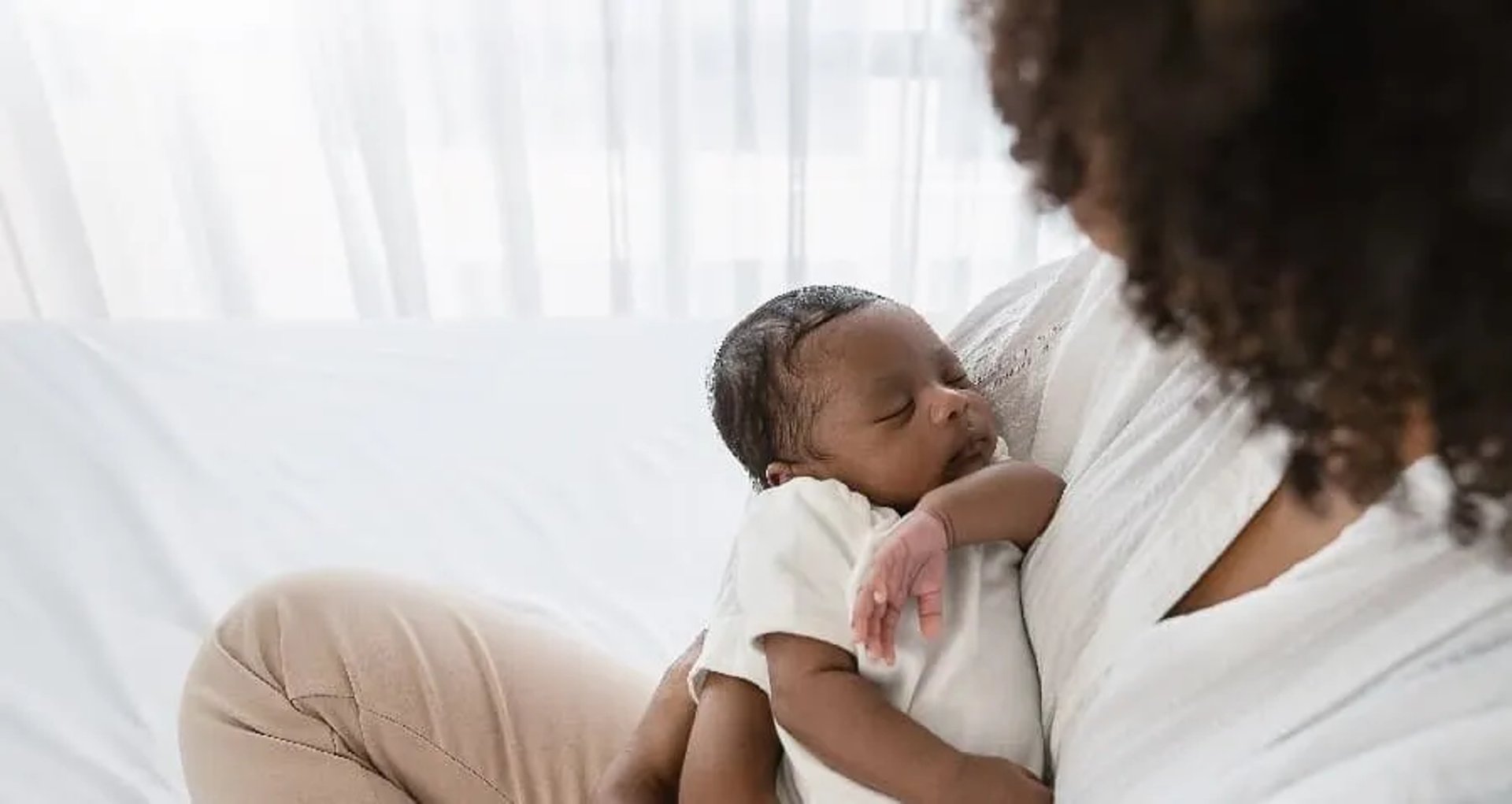 A pregnant woman standing in her crib