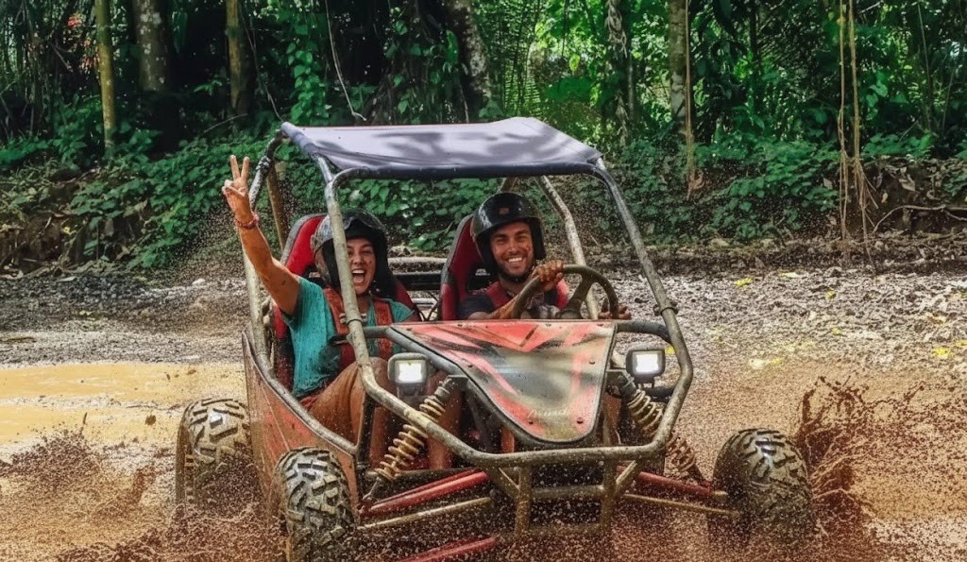 man riding red atv on brown field during daytime