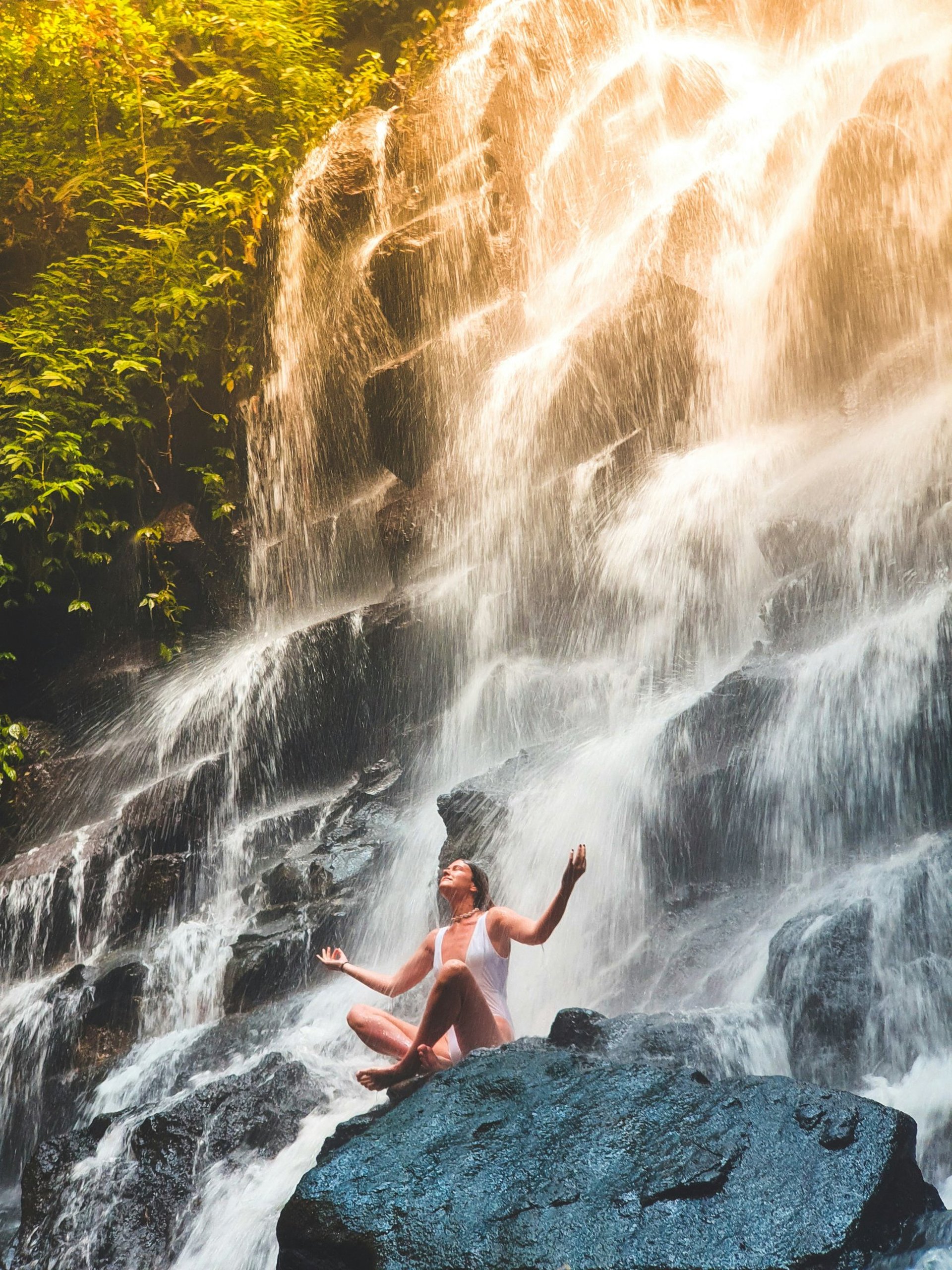 man squatting on mountain top during daytime