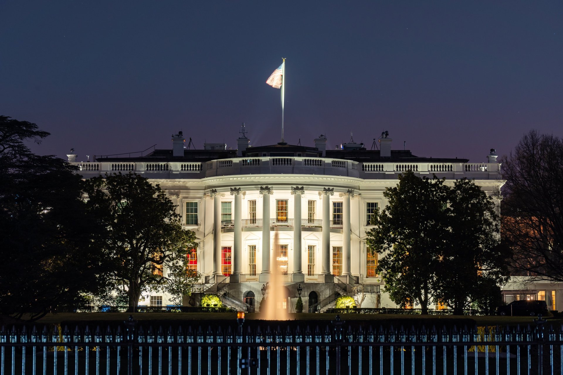 A white house with a black fence in front of it