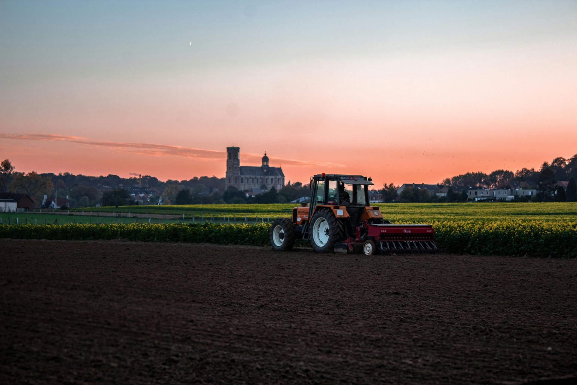 blue and black tractor on brown sand under blue sky during daytime