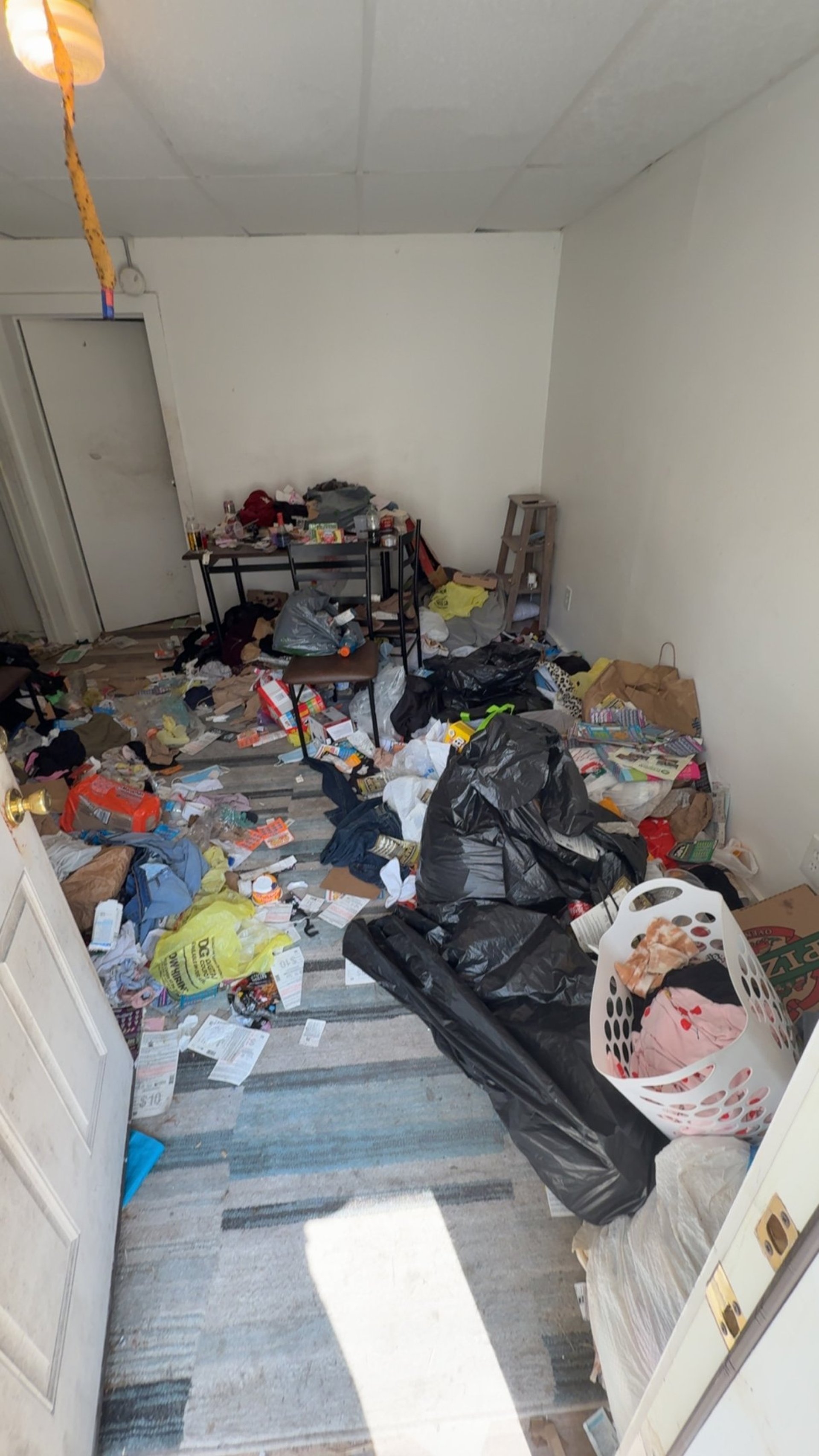 Crew carrying large appliance up basement stairs during removal service