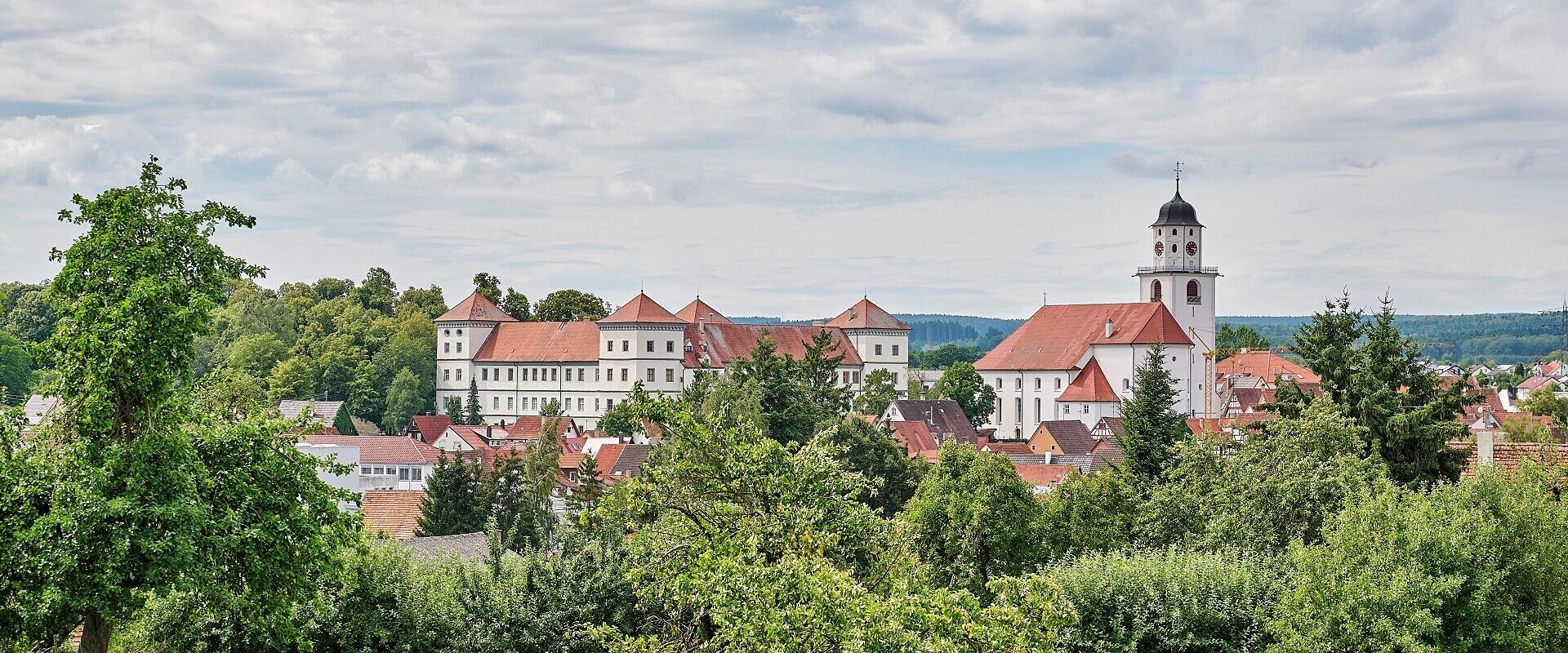 brown and white concrete houses beside river under blue sky during daytime