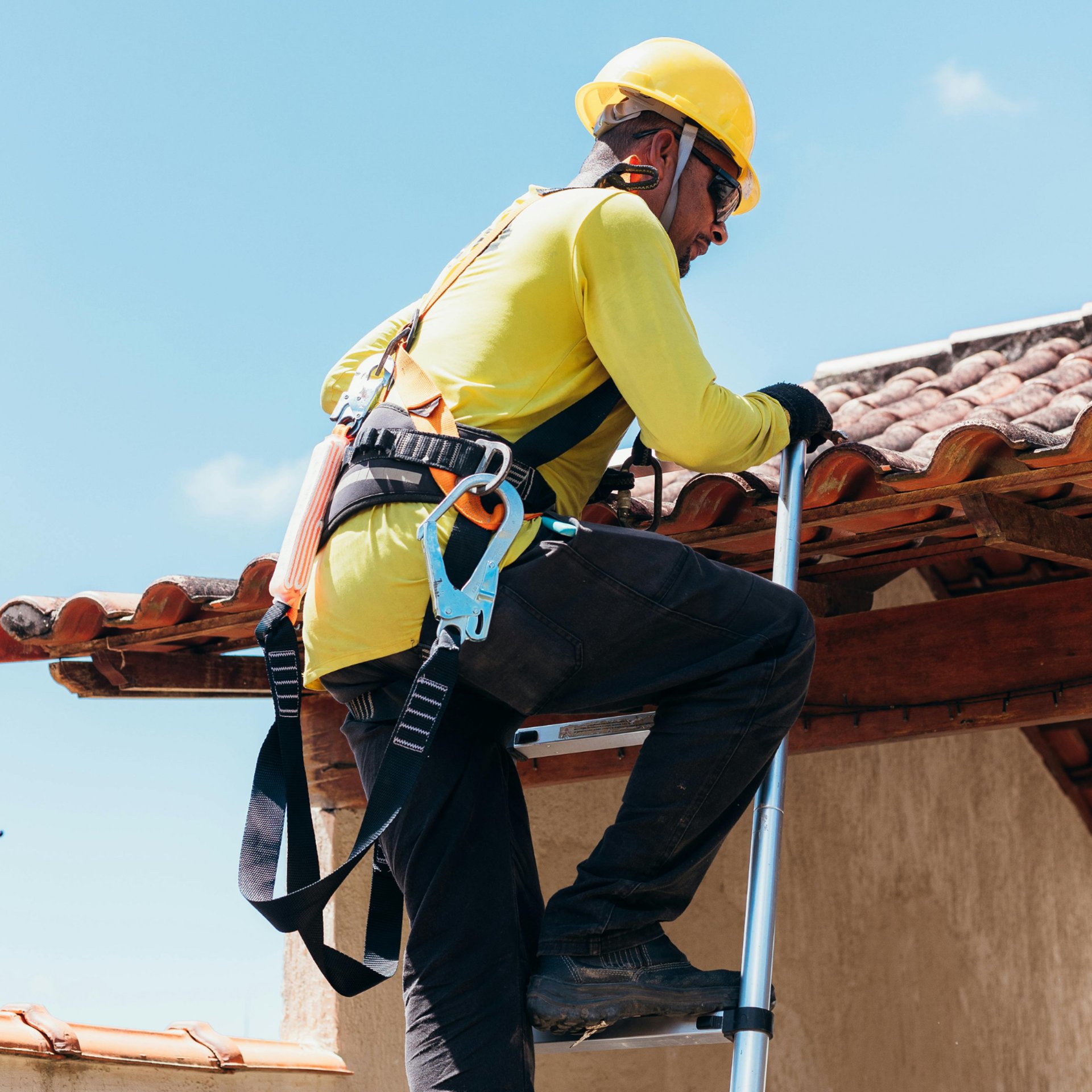 a man working on a roof with a power drill