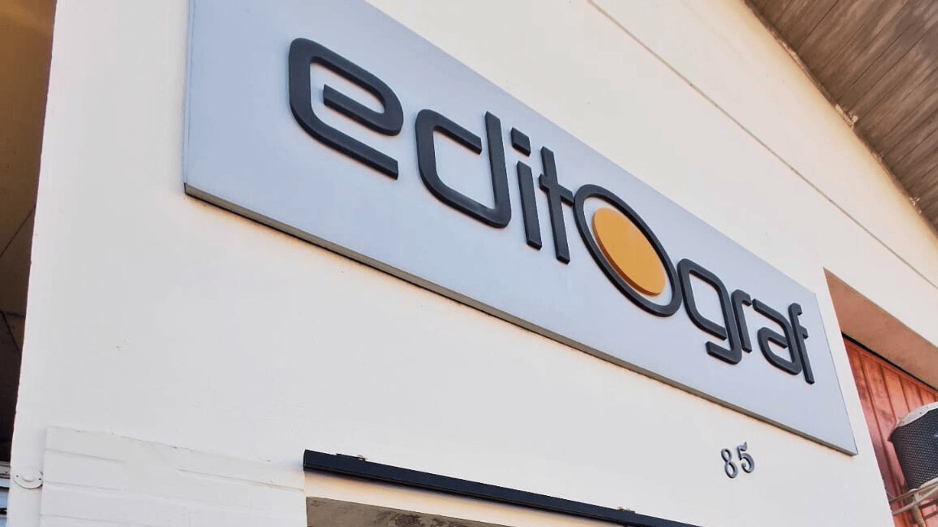 Fachada da gráfica Editograf em Florianópolis com o logo na placa.
