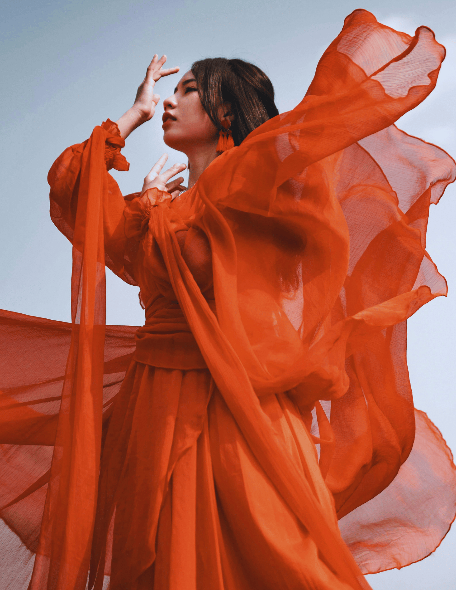 Empowered woman in red flowy dress, symbolizing a Phoenix rising as financial and spiritual freedom