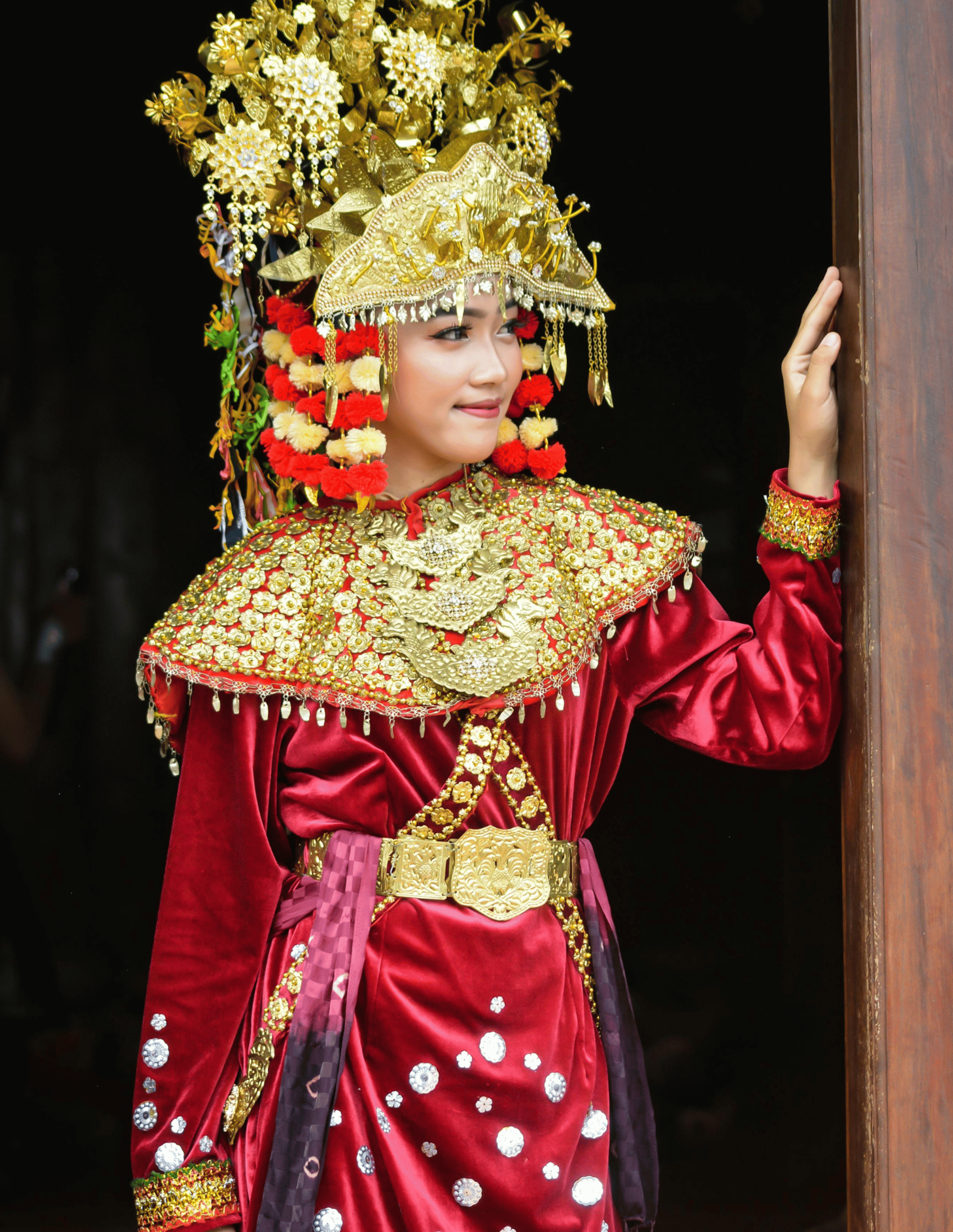 Empowered woman i red ethnic costume in a door frame, symbolizing Phoenix Ignited Brand-the Metal Archetype for precision