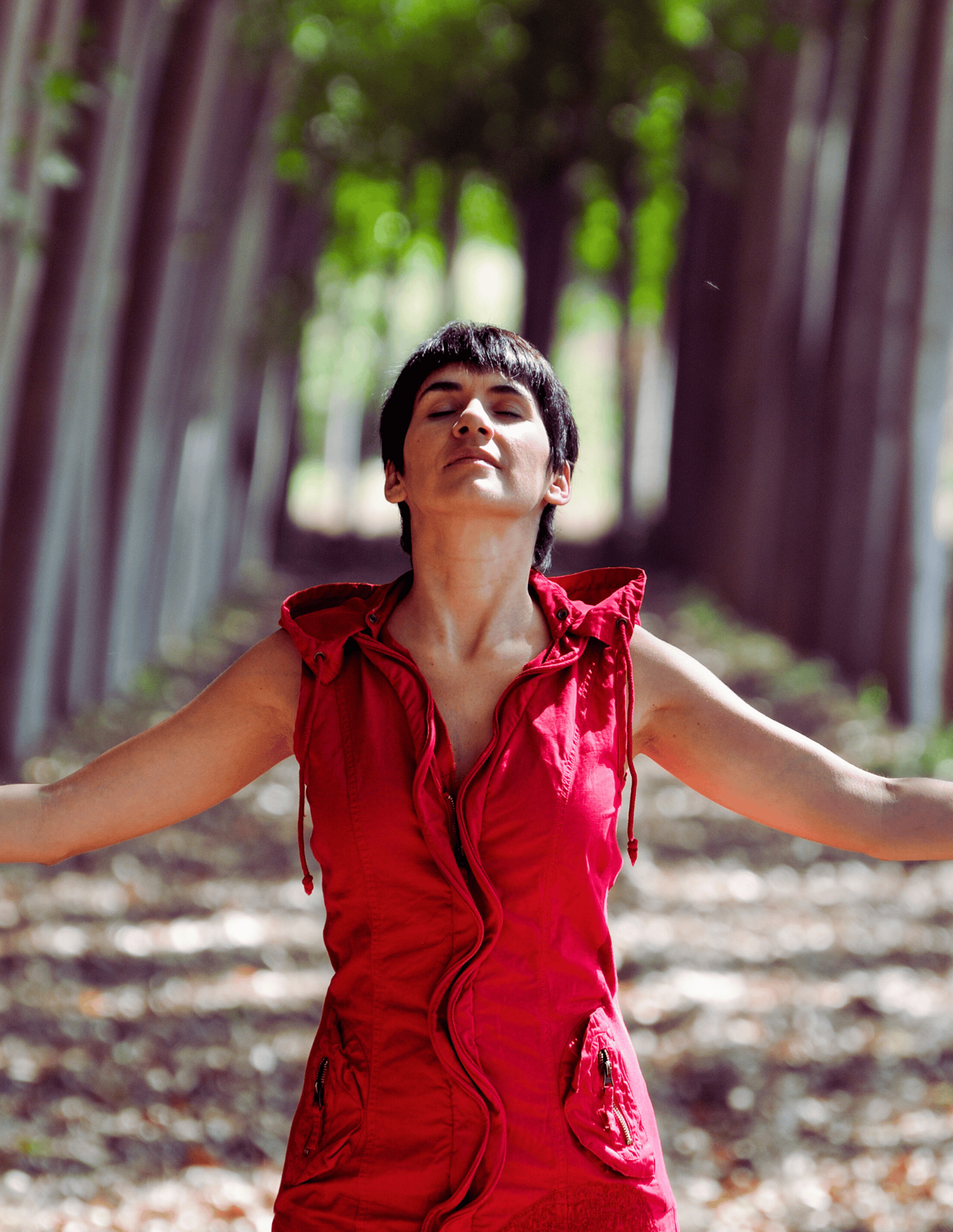 Empowered woman in red dress in the forest, symbolizing financial and spiritual freedom 