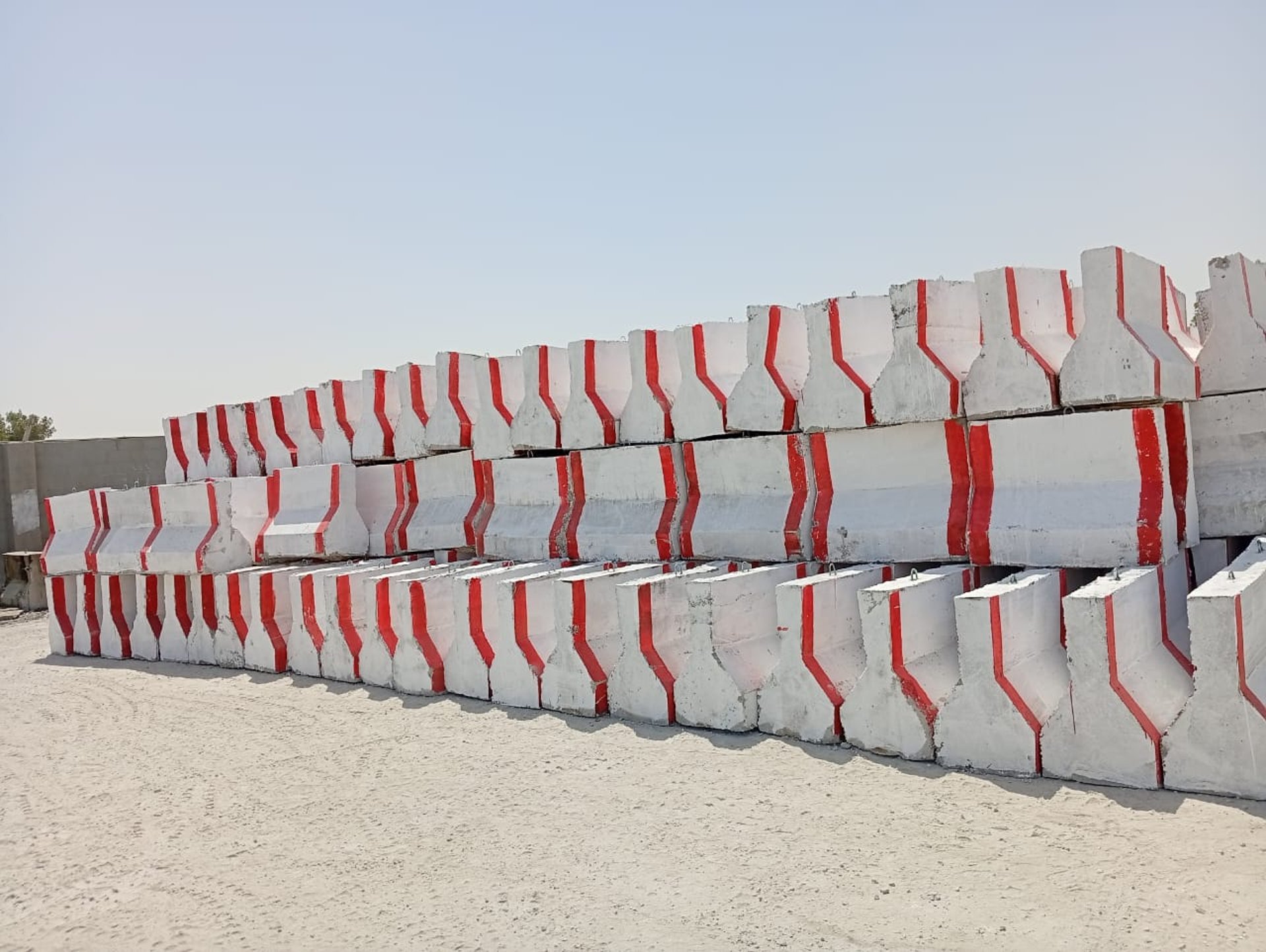 a walkway made out of cement blocks next to a body of water