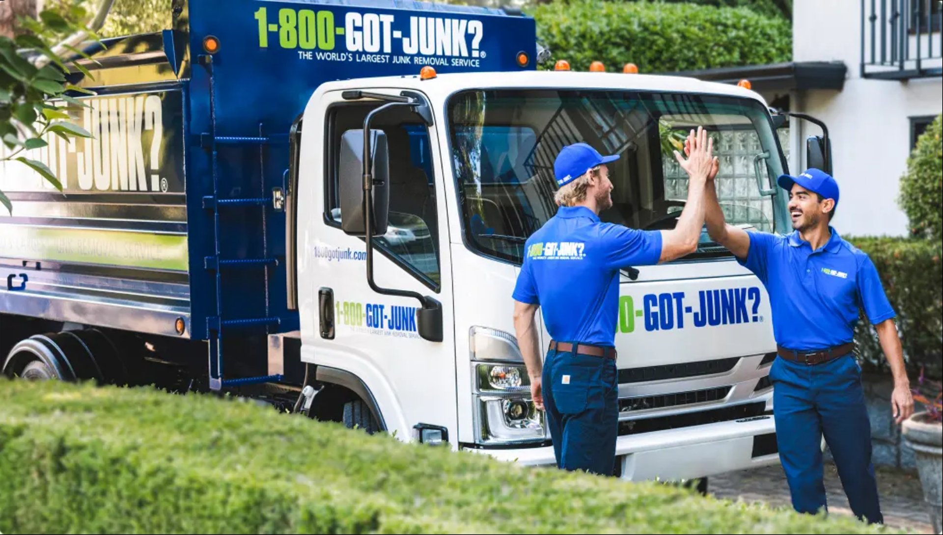 man in yellow shirt and blue denim jeans standing on white concrete building during daytime
