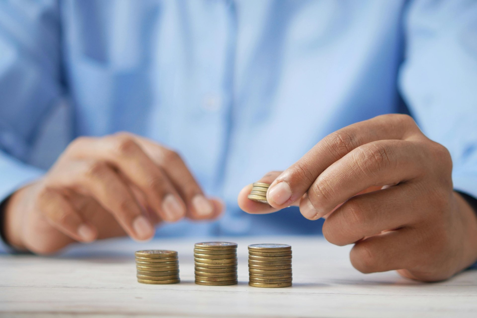 a person stacking coins on top of a table