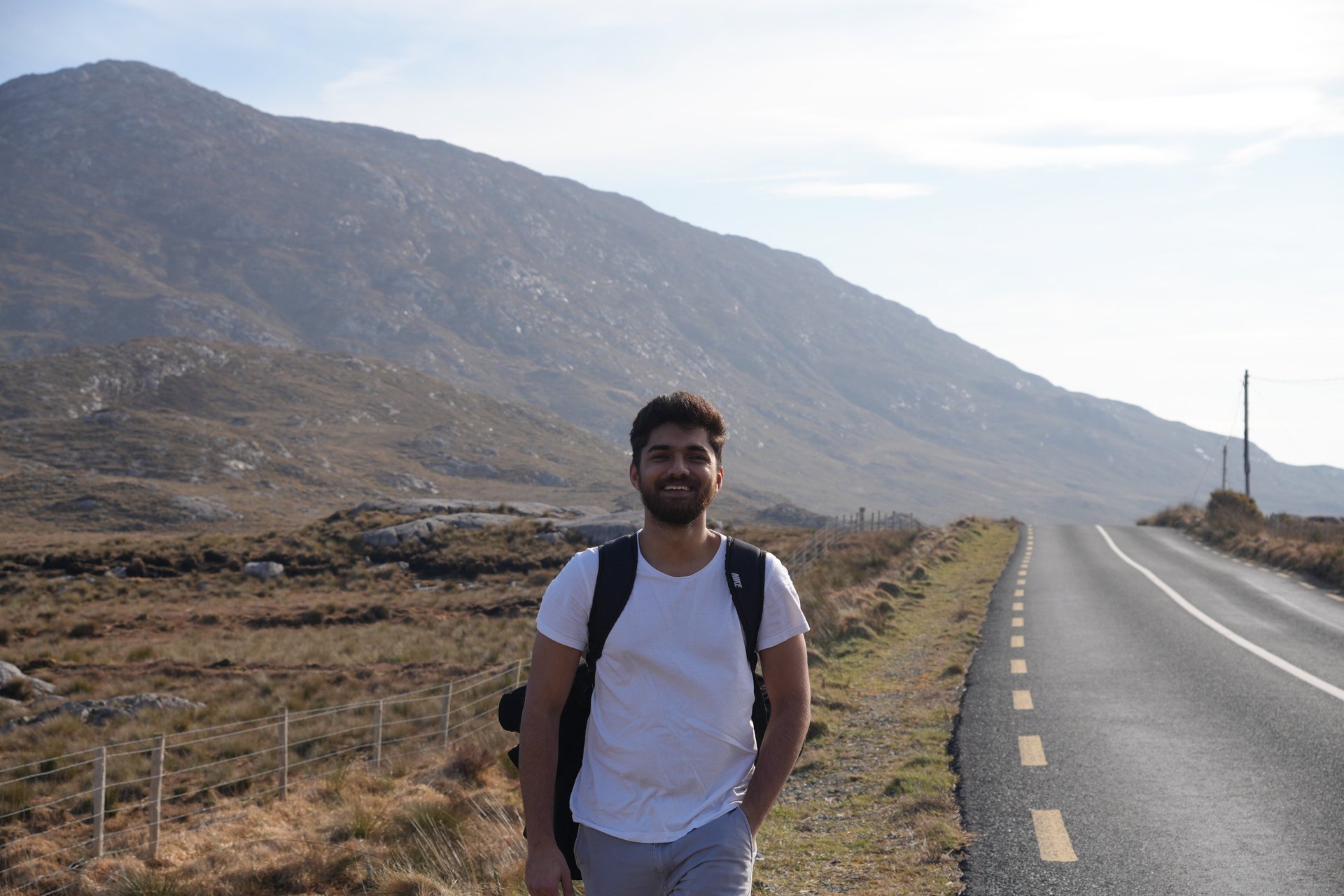 woman in black long sleeve shirt and blue denim jeans sitting on white concrete wall