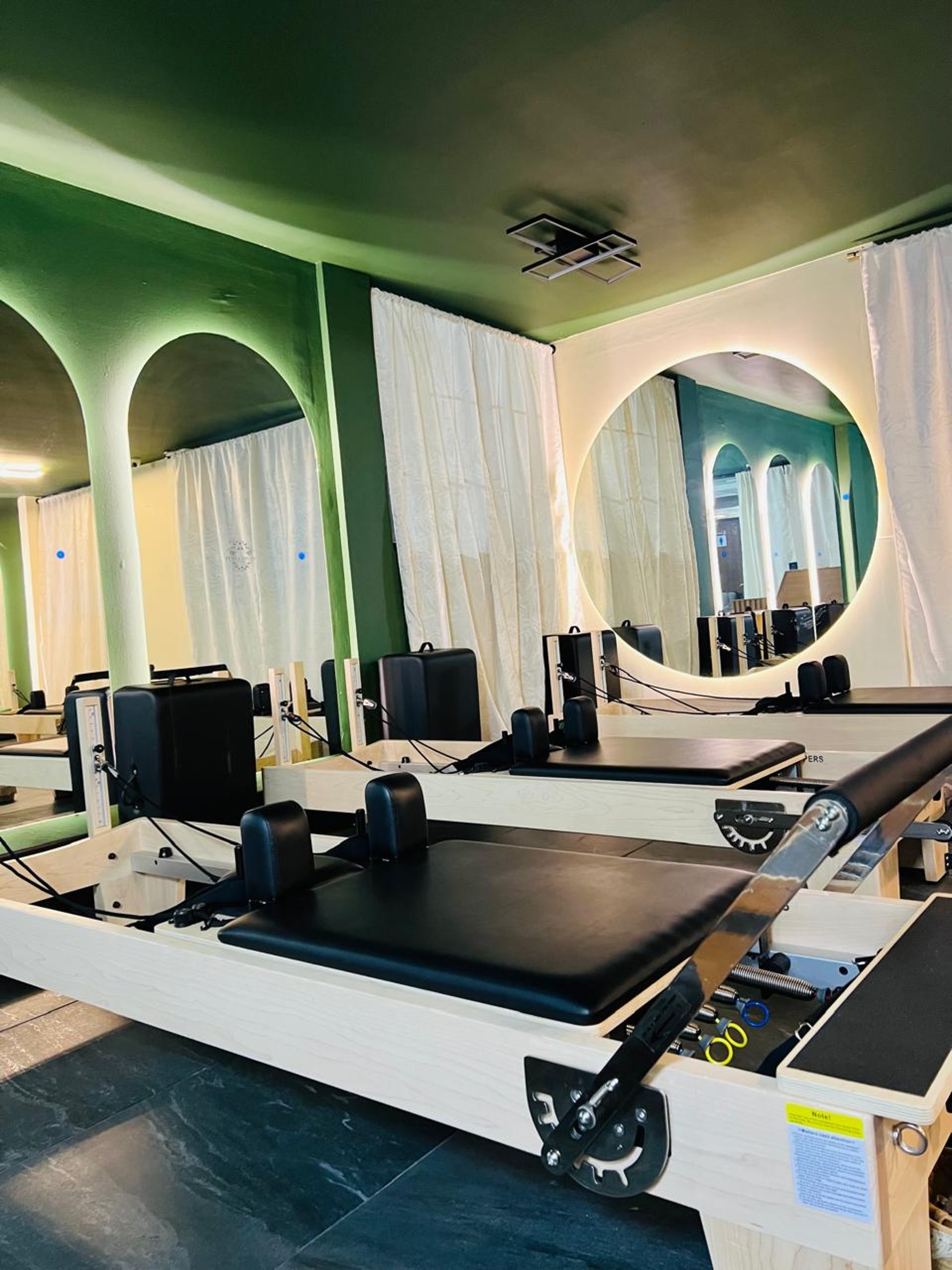 a gym with a row of machines and mirrors