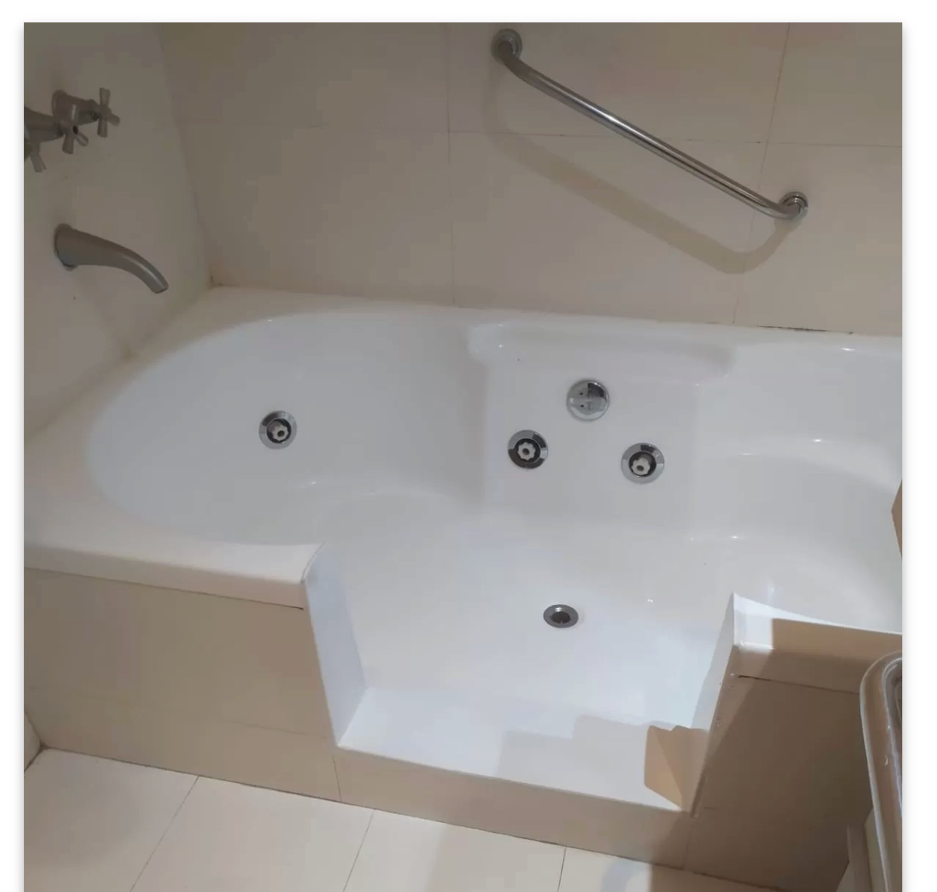 wooden ladder rack near white and black ceramic bathtub
