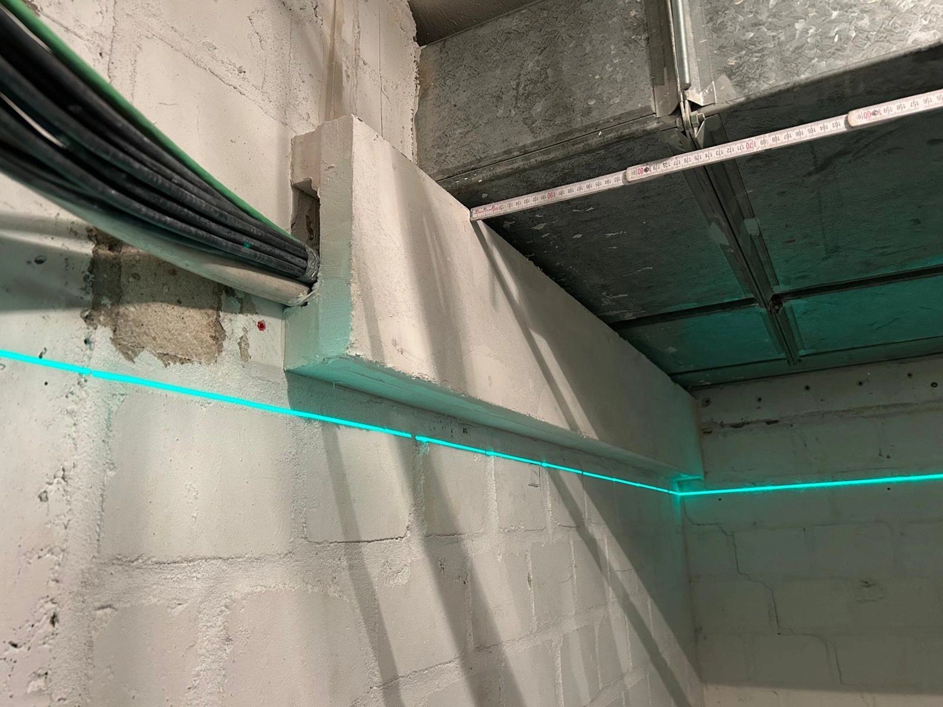 Zabudowa przeciwogniowa kanału wentylacyjnego w pomieszczeniu technicznym, płyty ognioodporne i widoczne przewody.