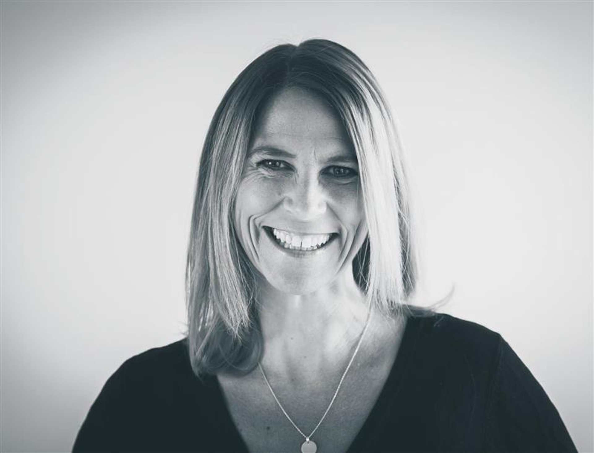 person writing on brown wooden table near white ceramic mug
