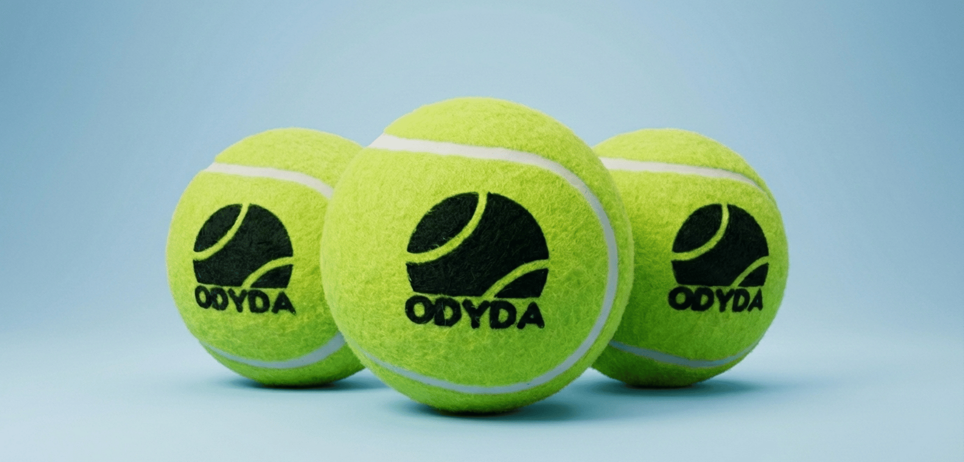 A woman sitting on the ground with a tennis racket and ball