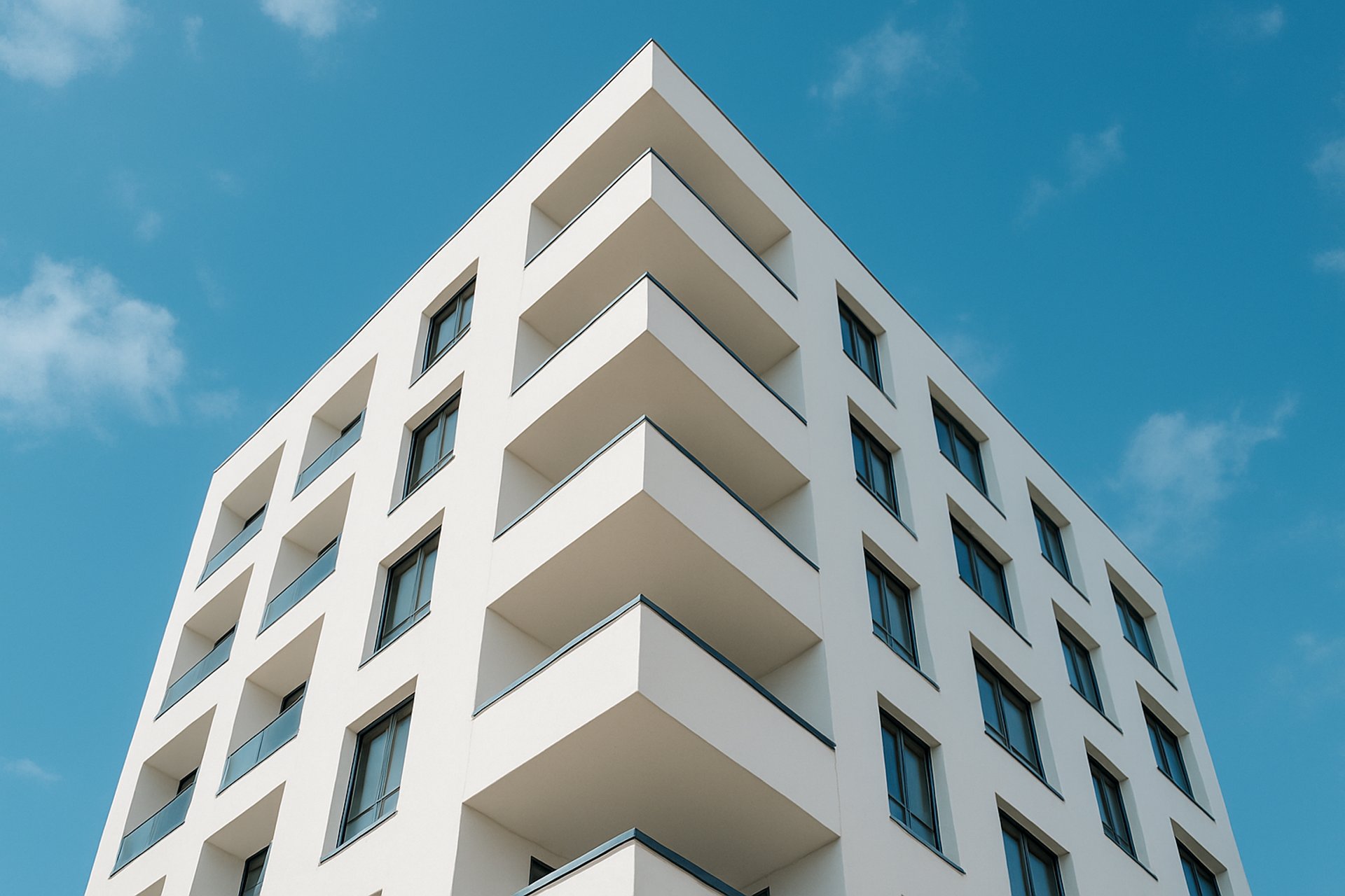 an abstract photo of a curved building with a blue sky in the background