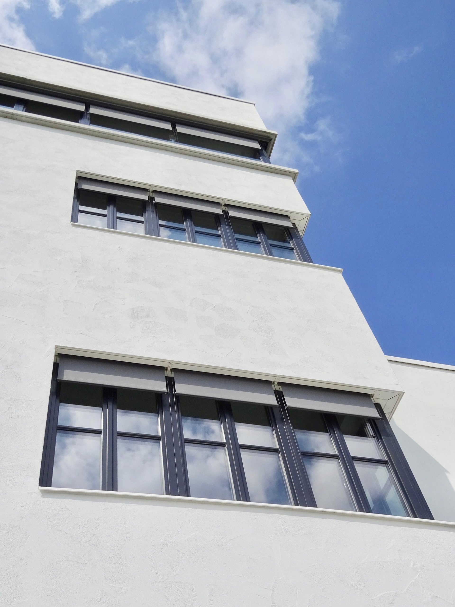 an abstract photo of a curved building with a blue sky in the background