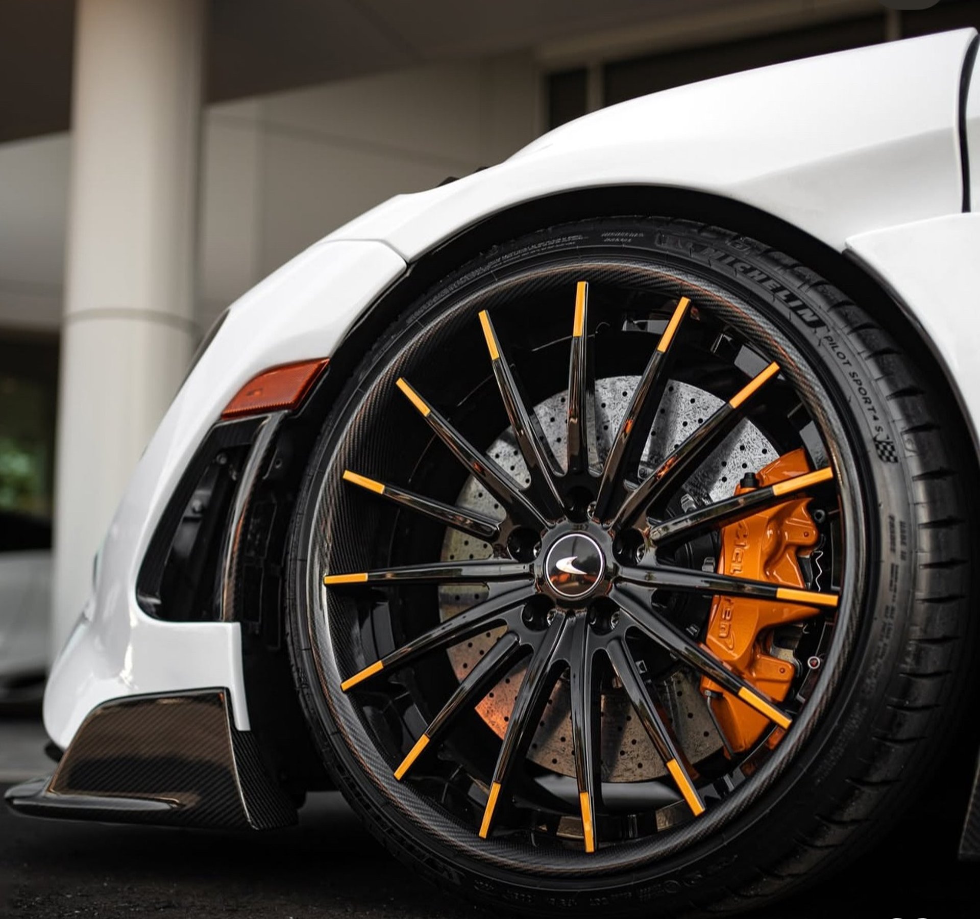 a white sports car parked in front of a building